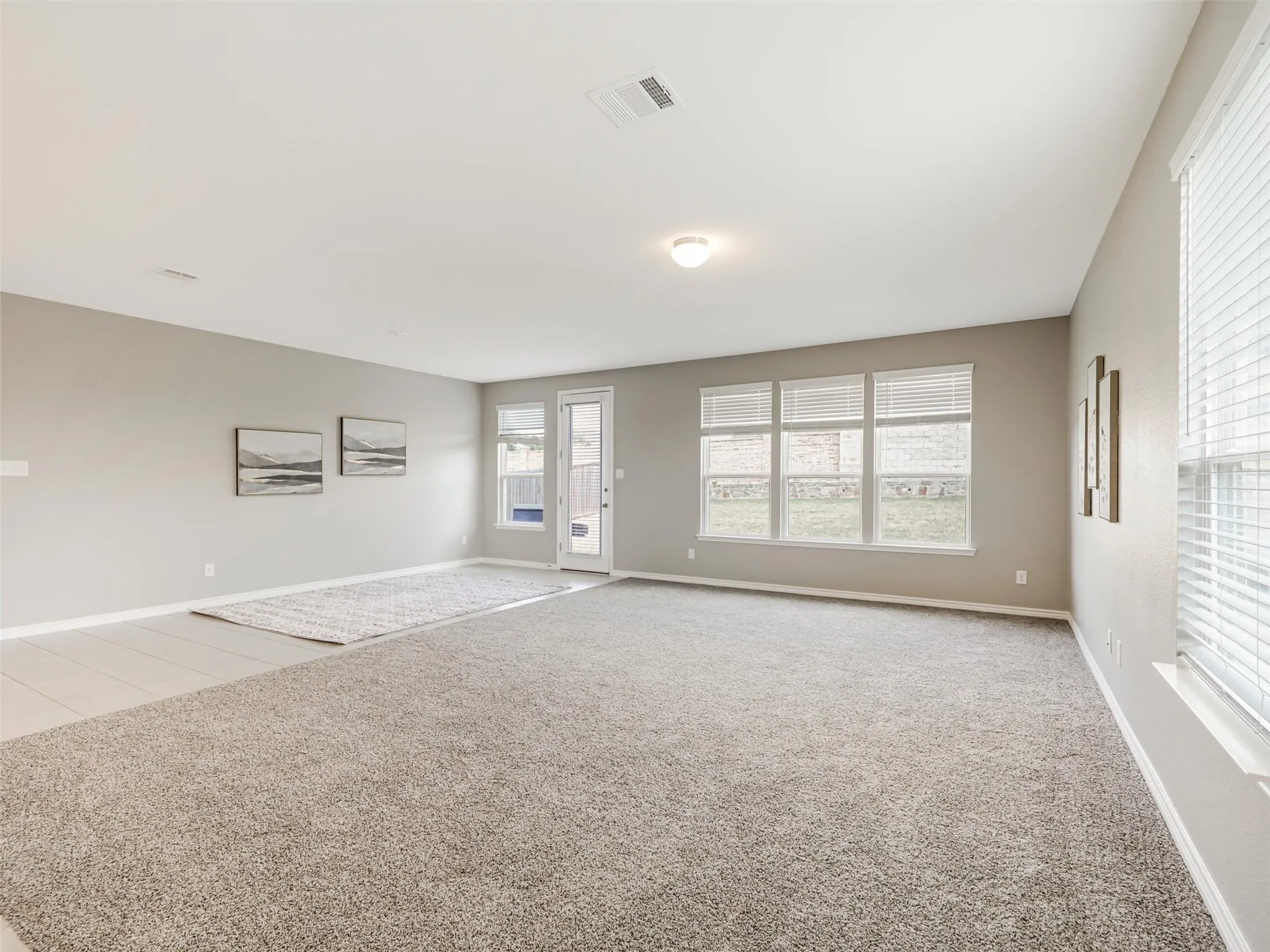 Expansive living area filled with natural light and offering plenty of room for comfortable seating and entertaining, with direct access to the backyard.