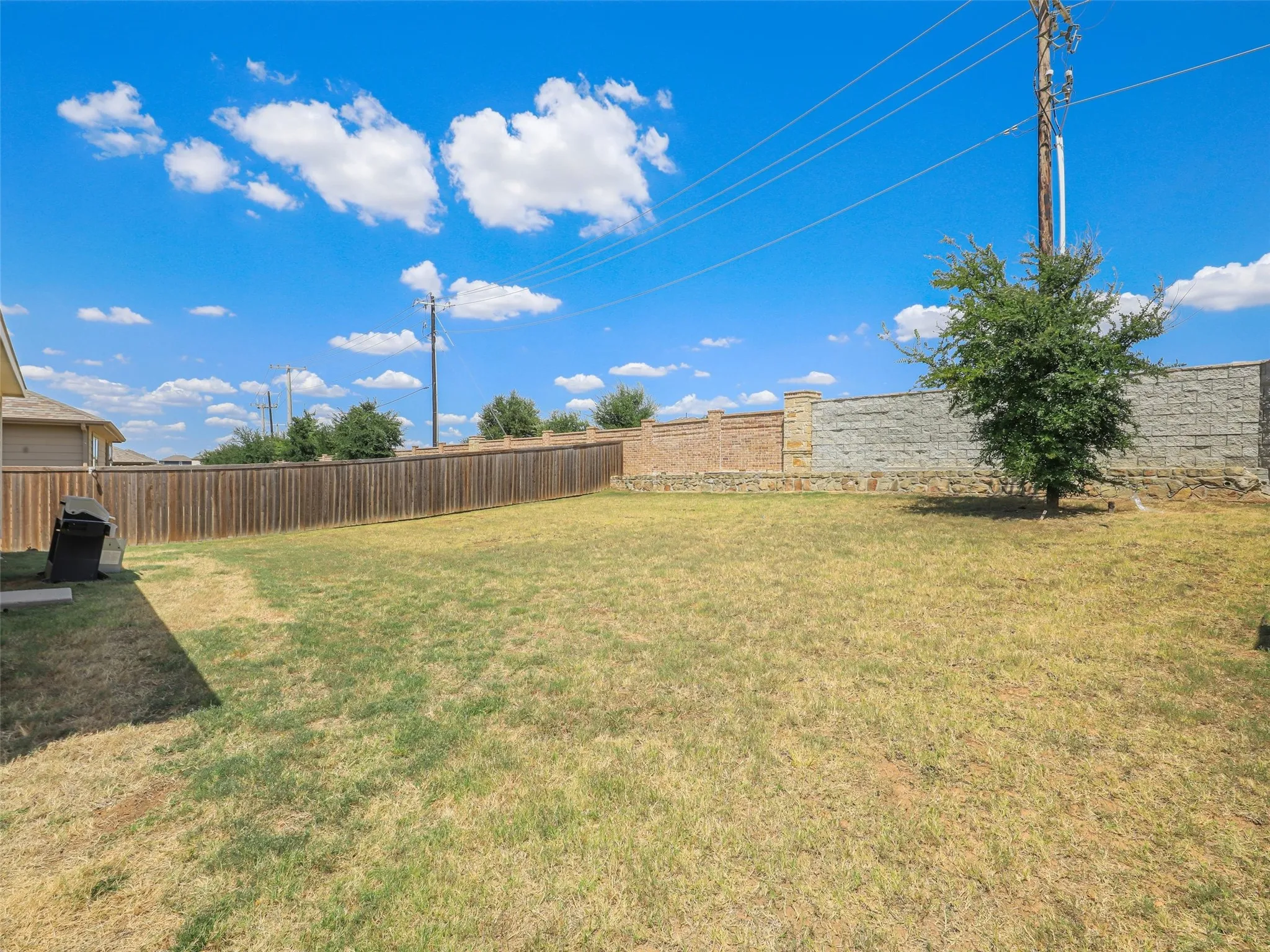 Expansive fenced backyard provides plenty of room for outdoor entertaining, gardening, recreation, or future improvements.