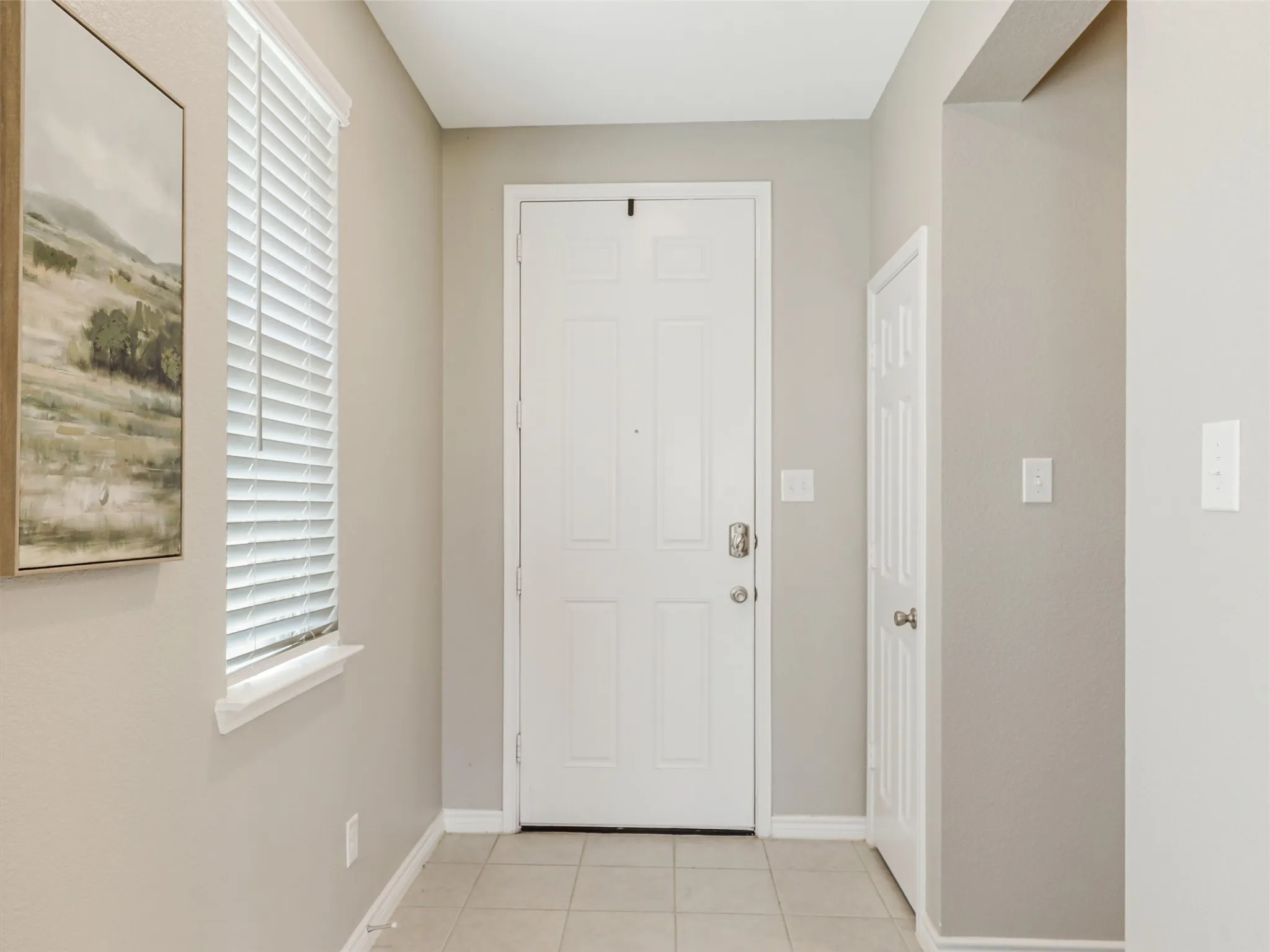 Bright and welcoming entryway with neutral colors, tile flooring, and natural light—setting a fresh tone from the moment you step inside.