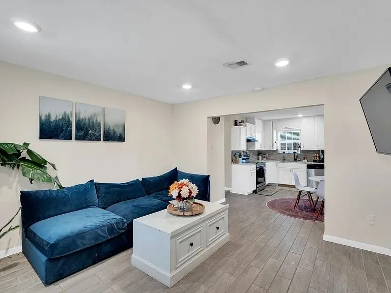 Wood-finish flooring throughout, featuring recessed lighting and a neutral color palette