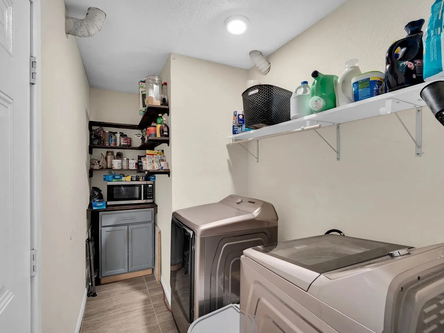 Built-in shelving, recessed ceiling lighting, and a utility cabinet with a countertop