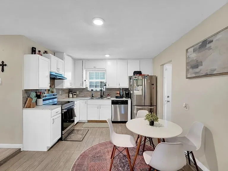 Bright and updated kitchen featuring white cabinetry, stainless steel appliances, and wood-finish flooring