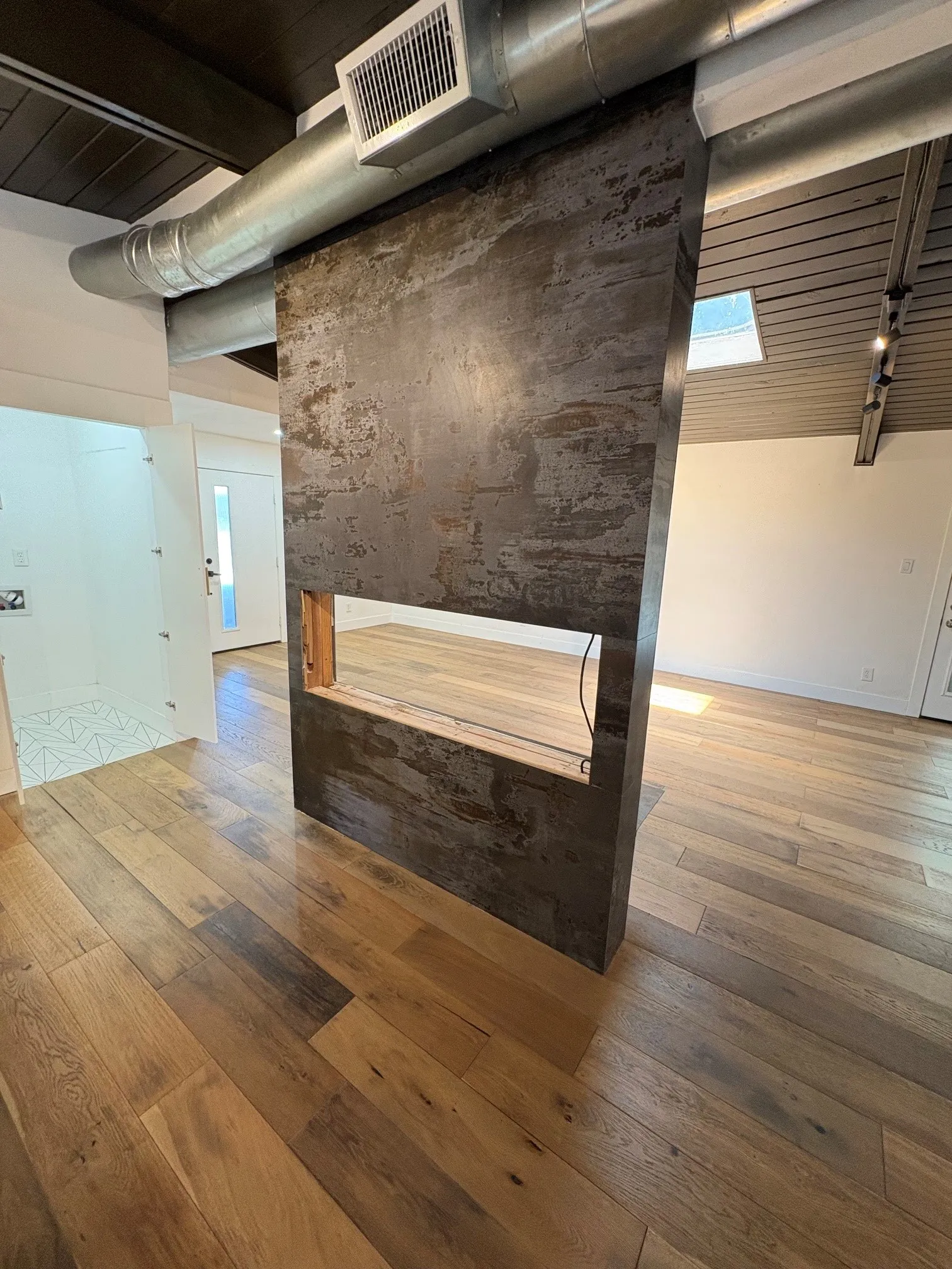 Electric fireplace has been removed from wall which separates the kitchen and living area.