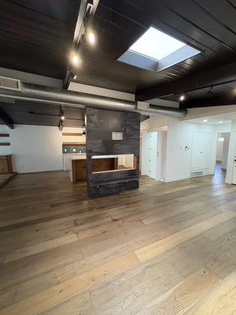 Living room with skylight is open to kitchen.
