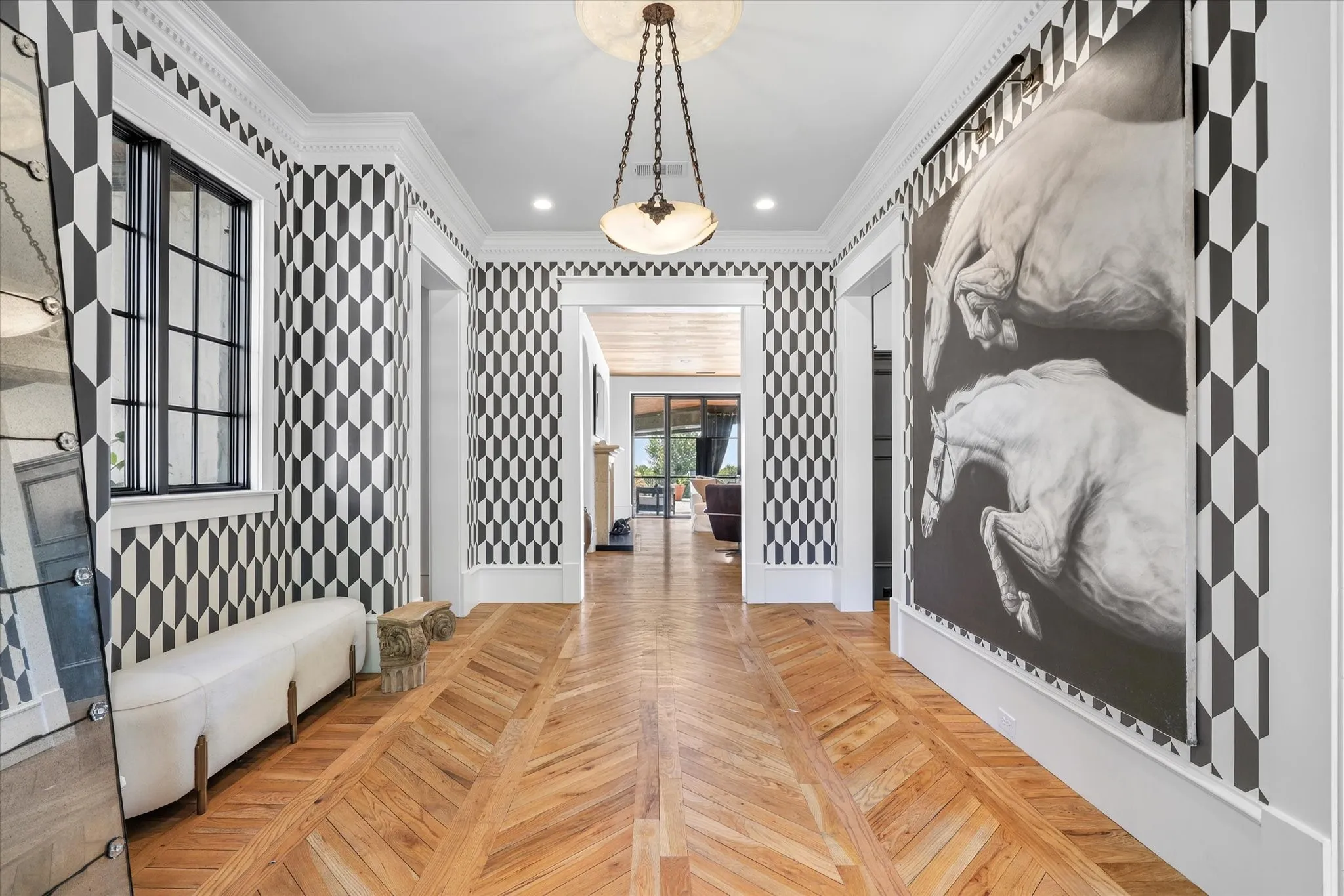 A memorable first impression with herringbone wood floors, graphic wall treatment and dramatic custom details.