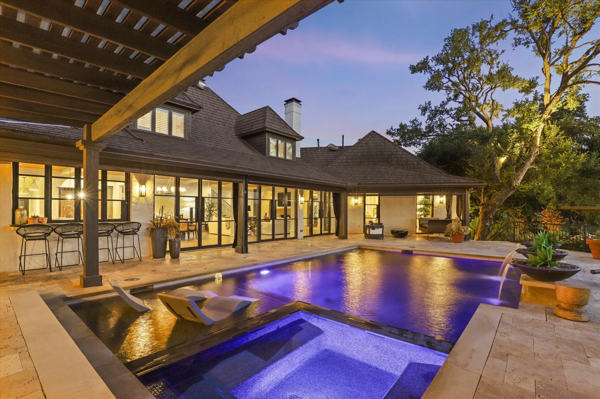 Evening lighting showcases the pool, spa and beautifully integrated outdoor living spaces.