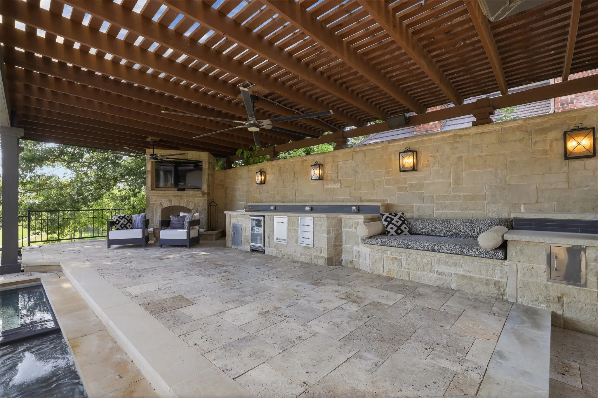 Expansive covered outdoor living with built-in kitchen, generous entertaining space and pergola-style ceiling.