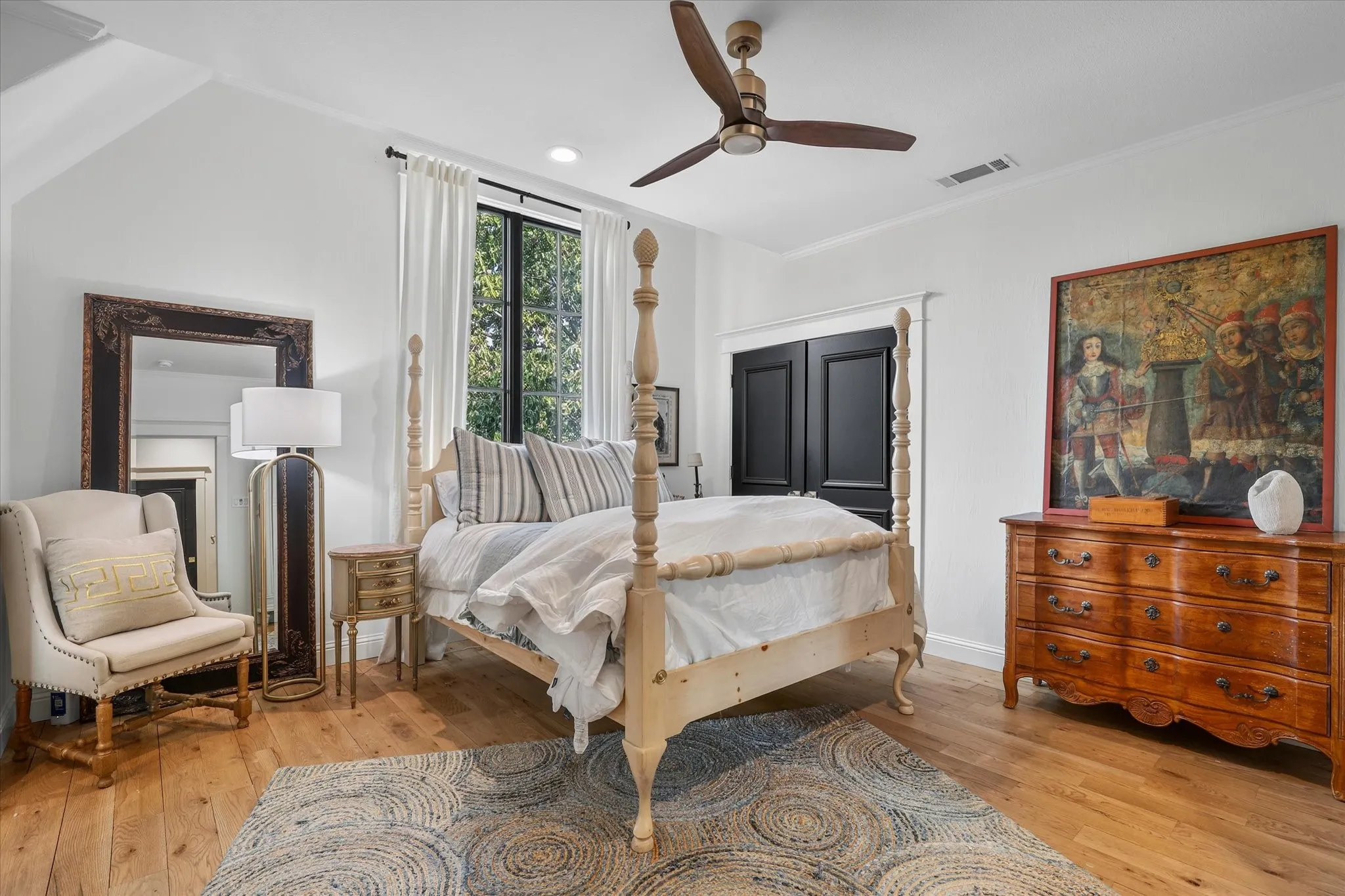 Spacious secondary bedroom with hardwood floors, abundant natural light and room for a comfortable sitting area.