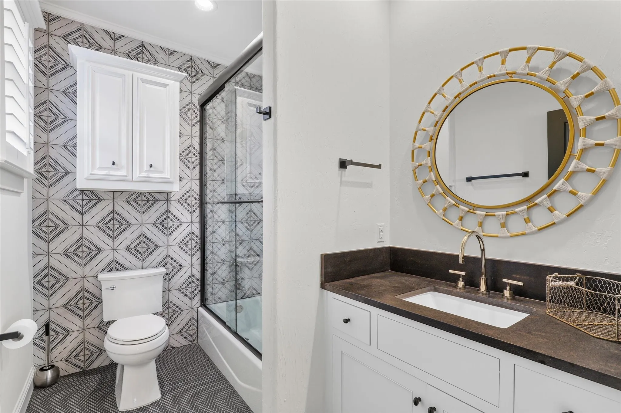 Stylish secondary bath with graphic tile, custom vanity and glass-enclosed tub/shower.