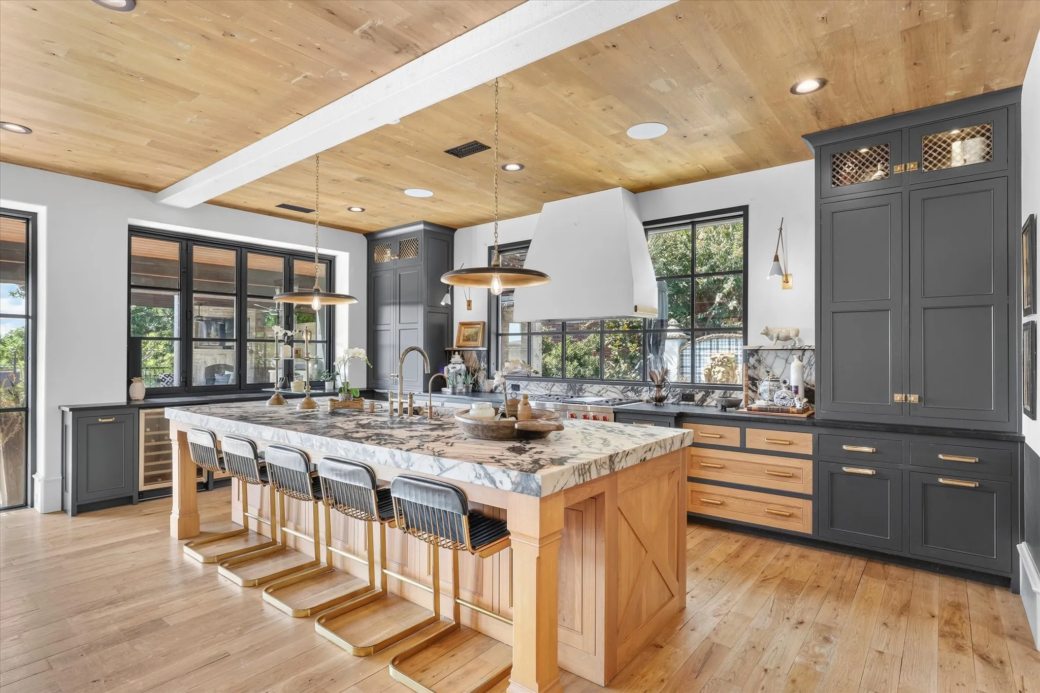 Showstopping chef’s kitchen with oversized island, custom cabinetry and an exceptional mix of natural wood and rich painted finishes.