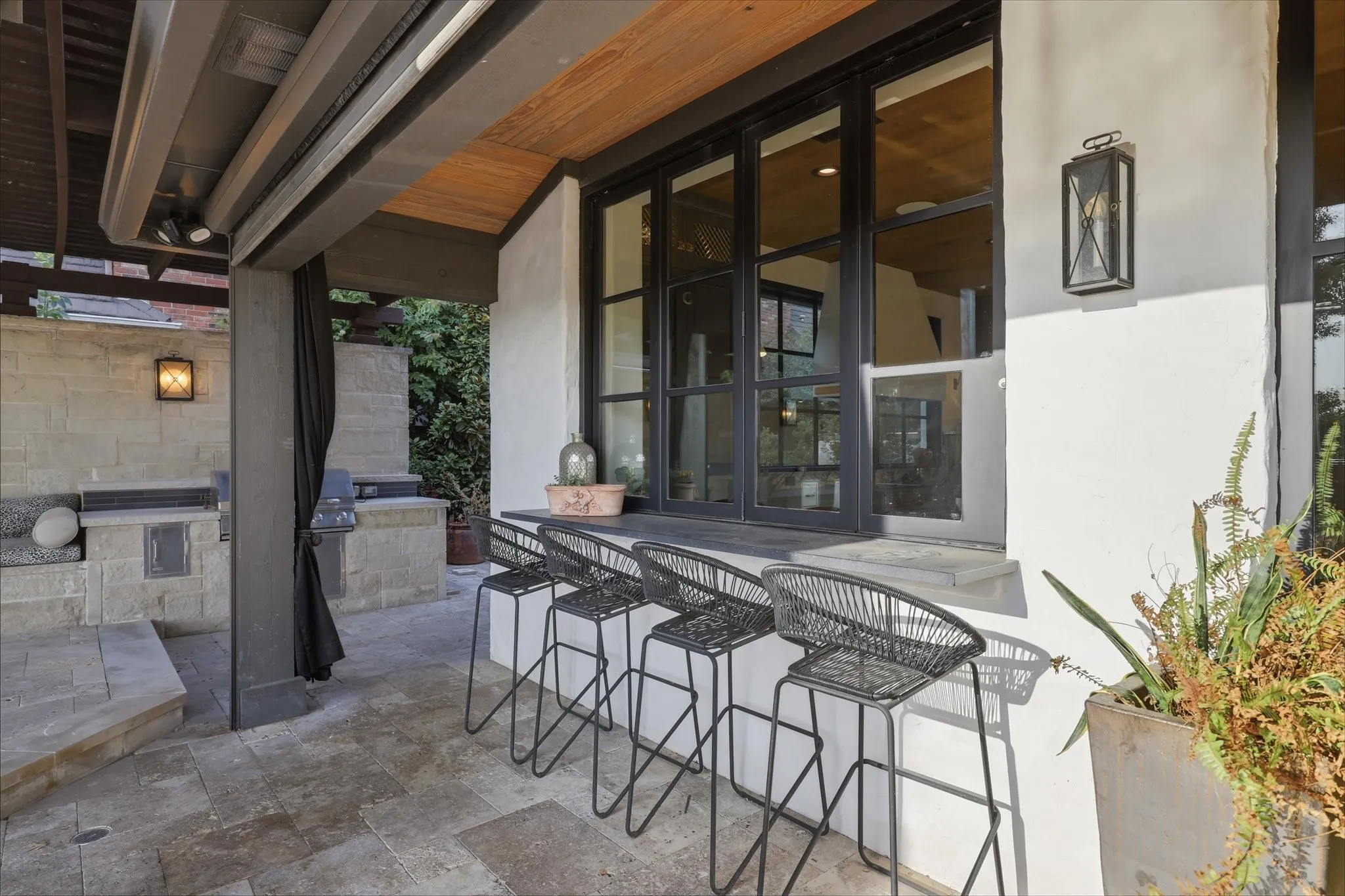 Convenient outdoor bar seating connects directly to the covered entertaining area and interior living spaces.
