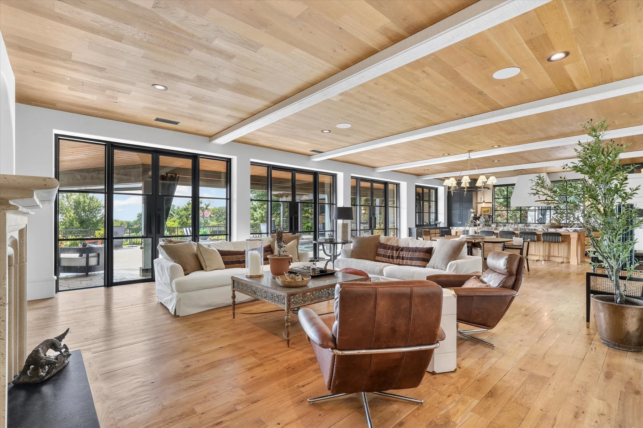 Expansive family room where warm wood ceilings and walls of modern windows and doors create a seamless connection to the outdoors.