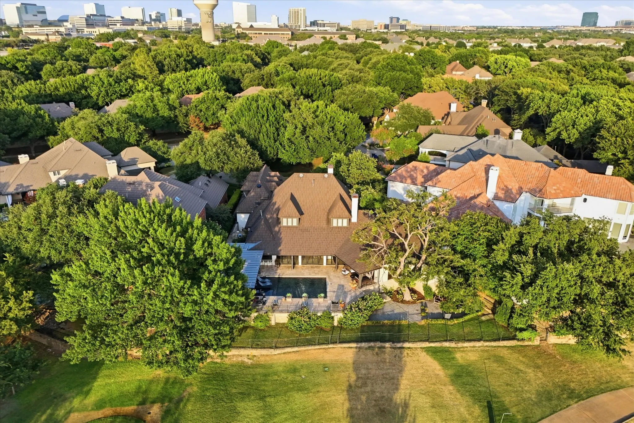 Beautiful rear elevation overlooking the pool and terraces with the golf course just beyond.