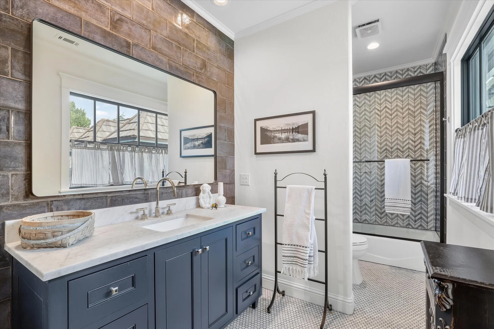 Beautifully updated bath with custom cabinetry, designer finishes and a striking tiled shower.