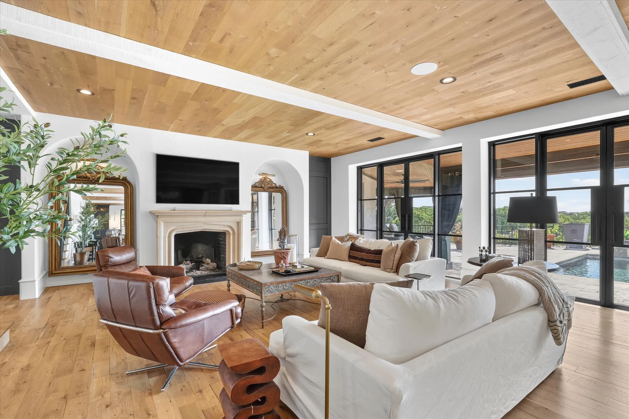 Fireplace anchors the inviting family room, surrounded by beautiful architectural details and views of the pool.