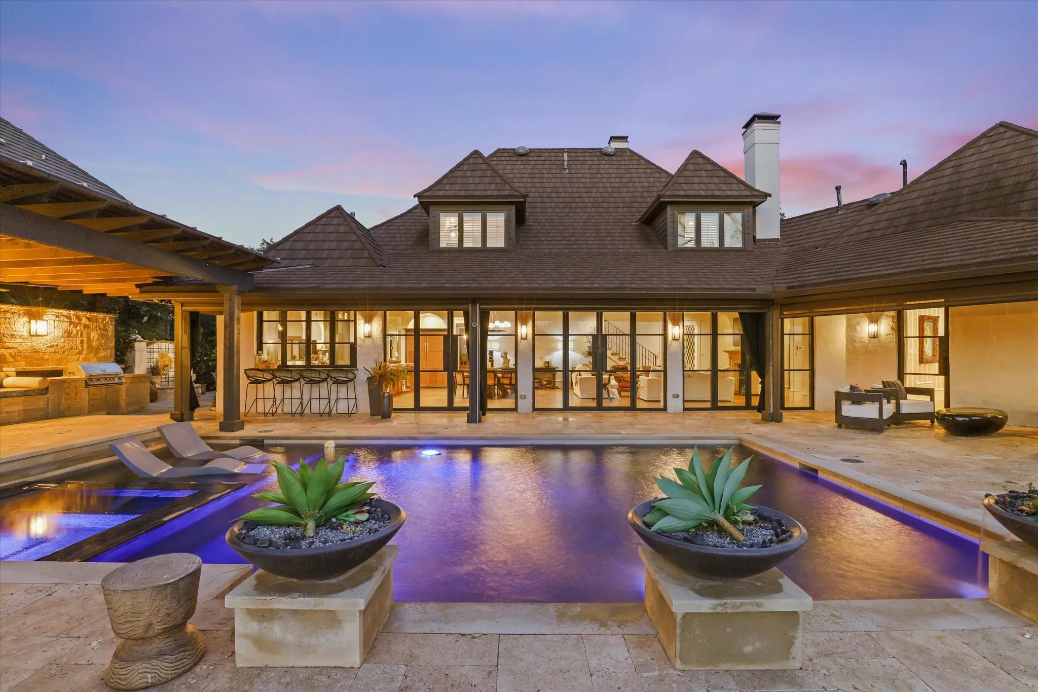 Resort-style outdoor living with pool, expansive terraces and walls of windows connecting the home to the outdoors.