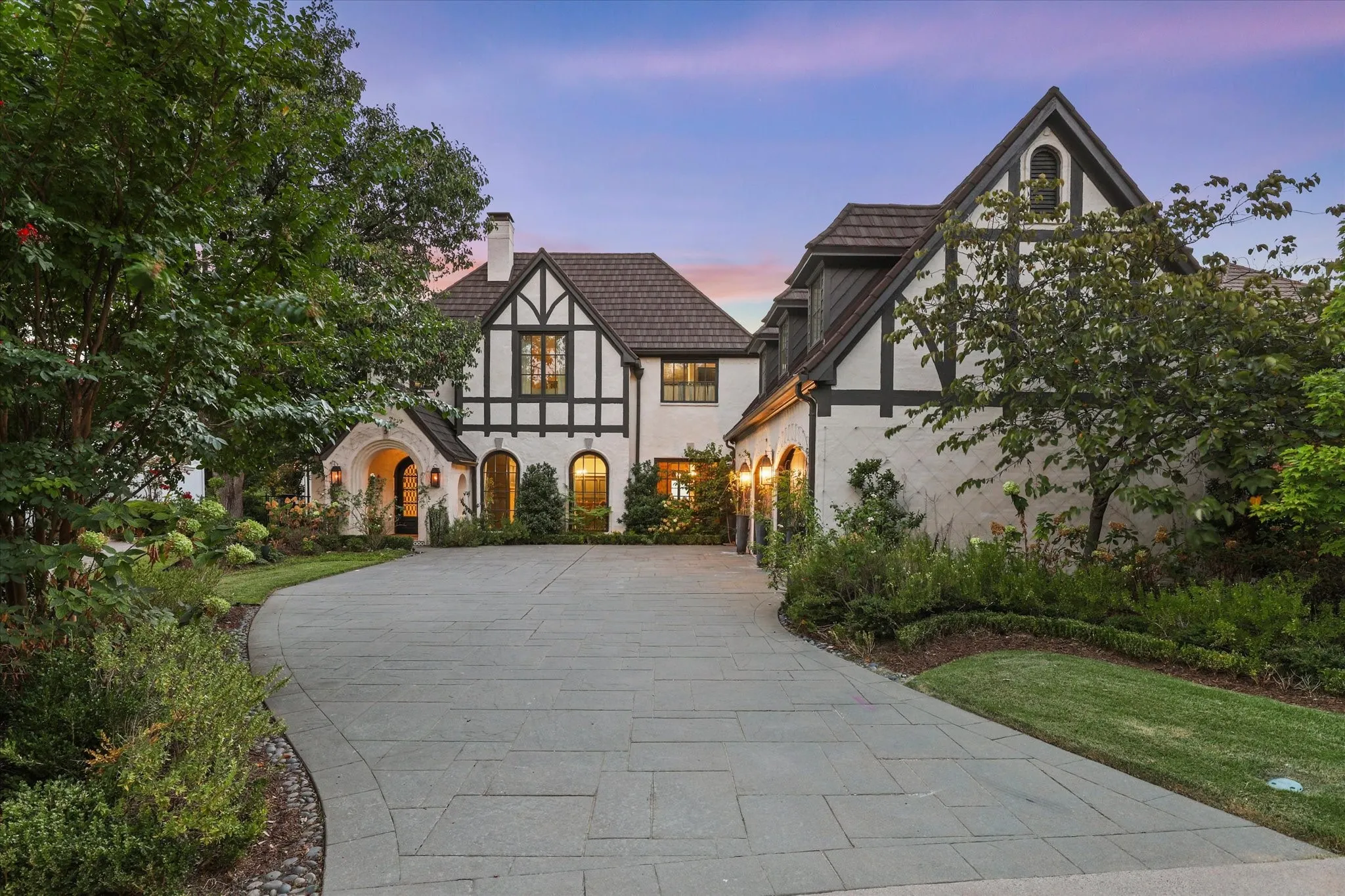 Striking Tudor-inspired architecture framed by mature landscaping and a beautifully private approach.