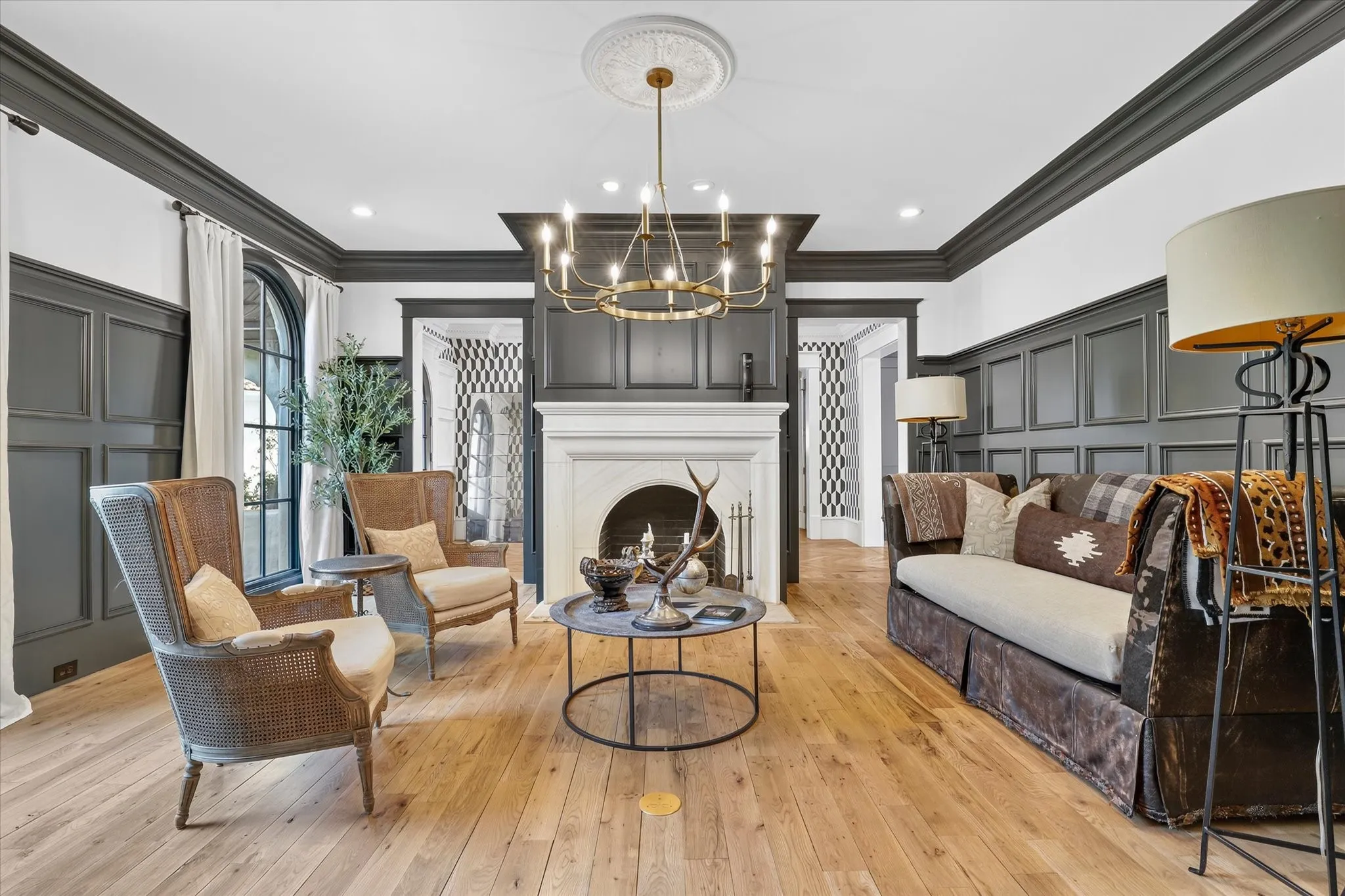 Sophisticated formal living room with fireplace, custom millwork and a beautifully layered designer aesthetic.
