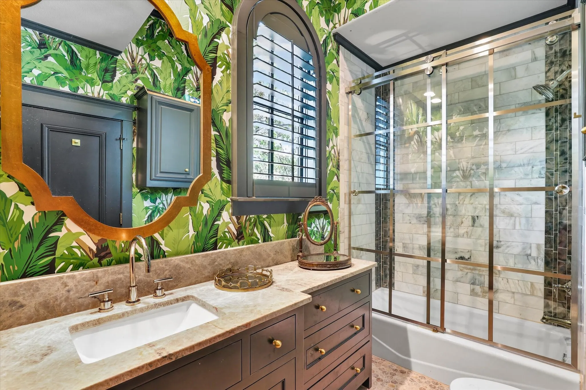 One-of-a-kind secondary bath brings an unexpected designer moment with bold finishes and a glass-enclosed shower.