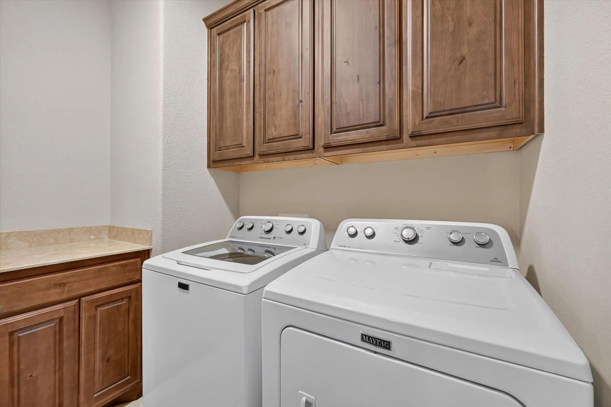 Upper wood-finish cabinetry, lower wood-finish cabinetry, and stone-finish countertop