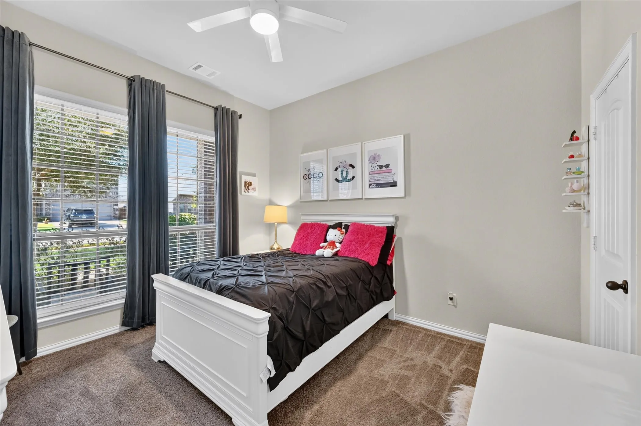 Bright secondary bedroom showcasing a white wood bed frame, carpet flooring, and neutral wall finishes