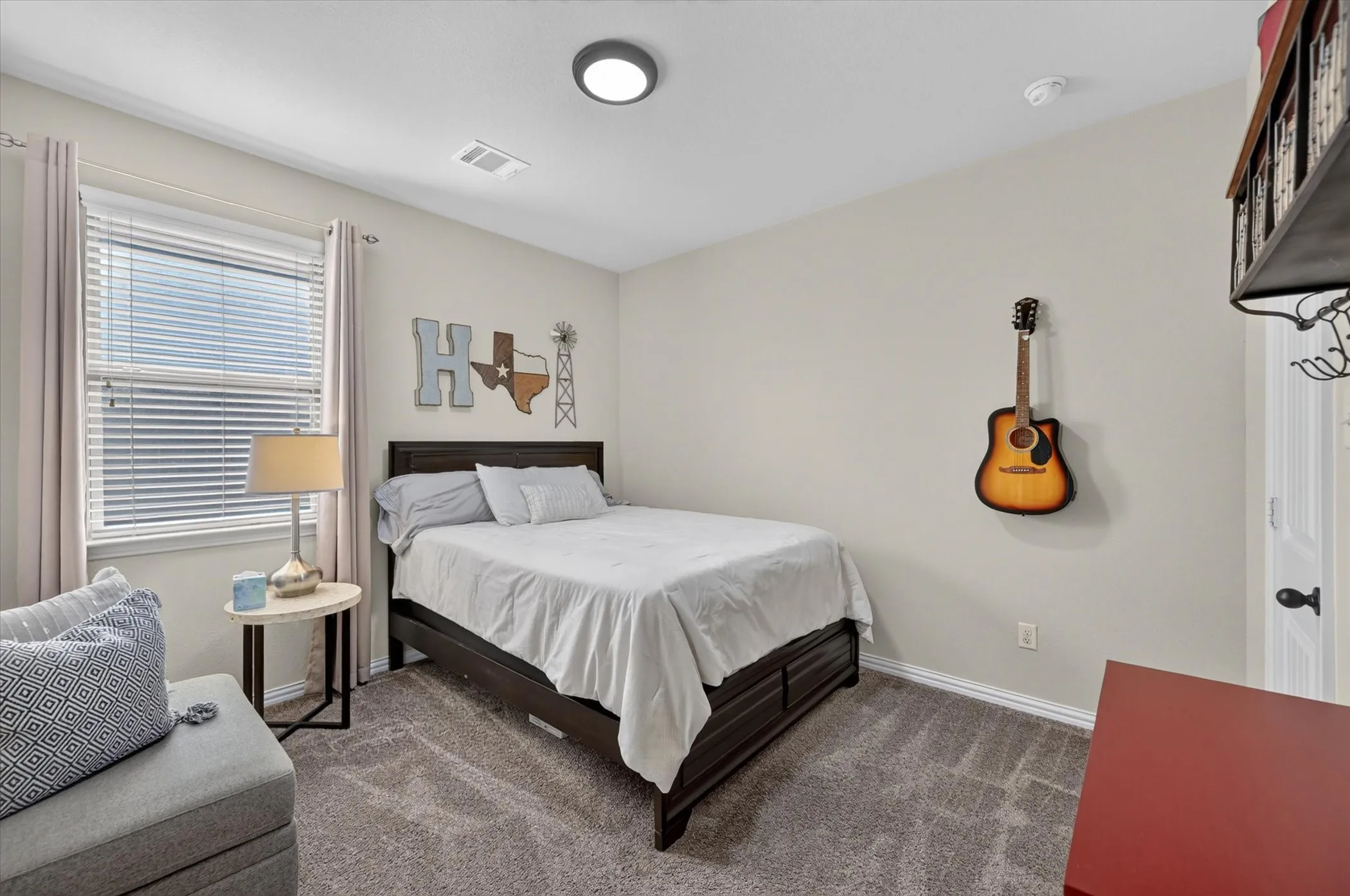 Comfortable secondary bedroom with wood-finish flooring, recessed ceiling lighting, and large window with blinds and thermal curtains