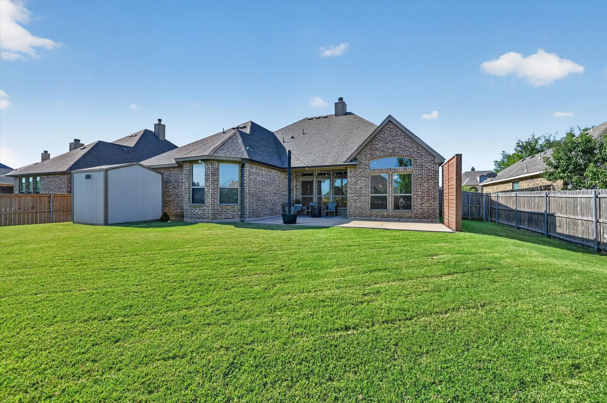 Expansive green lawn with a privacy fence