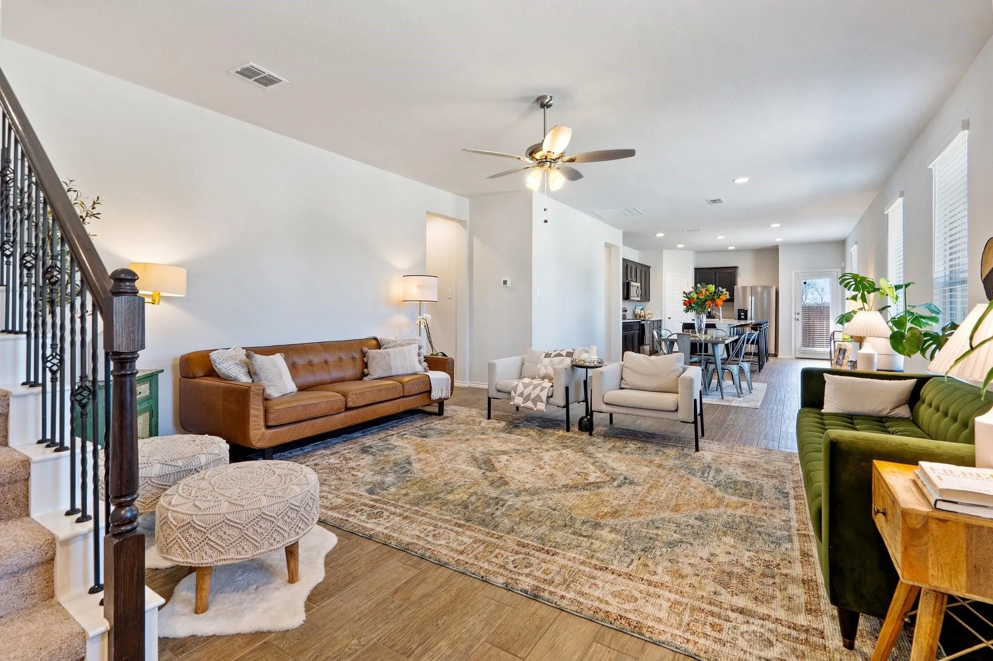 Living room with wood finished floors, stairs, ceiling fan, visible vents, and recessed lighting