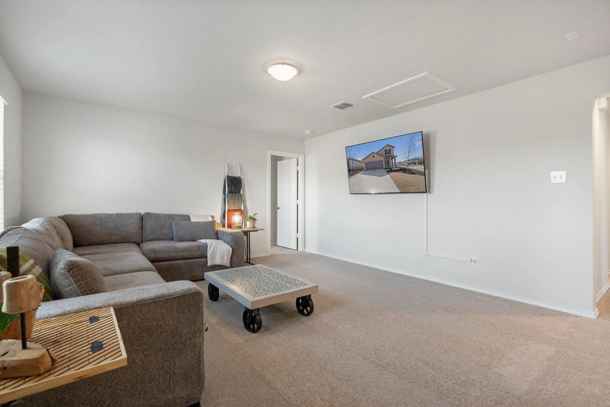 Living room featuring attic access, baseboards, visible vents, and carpet flooring