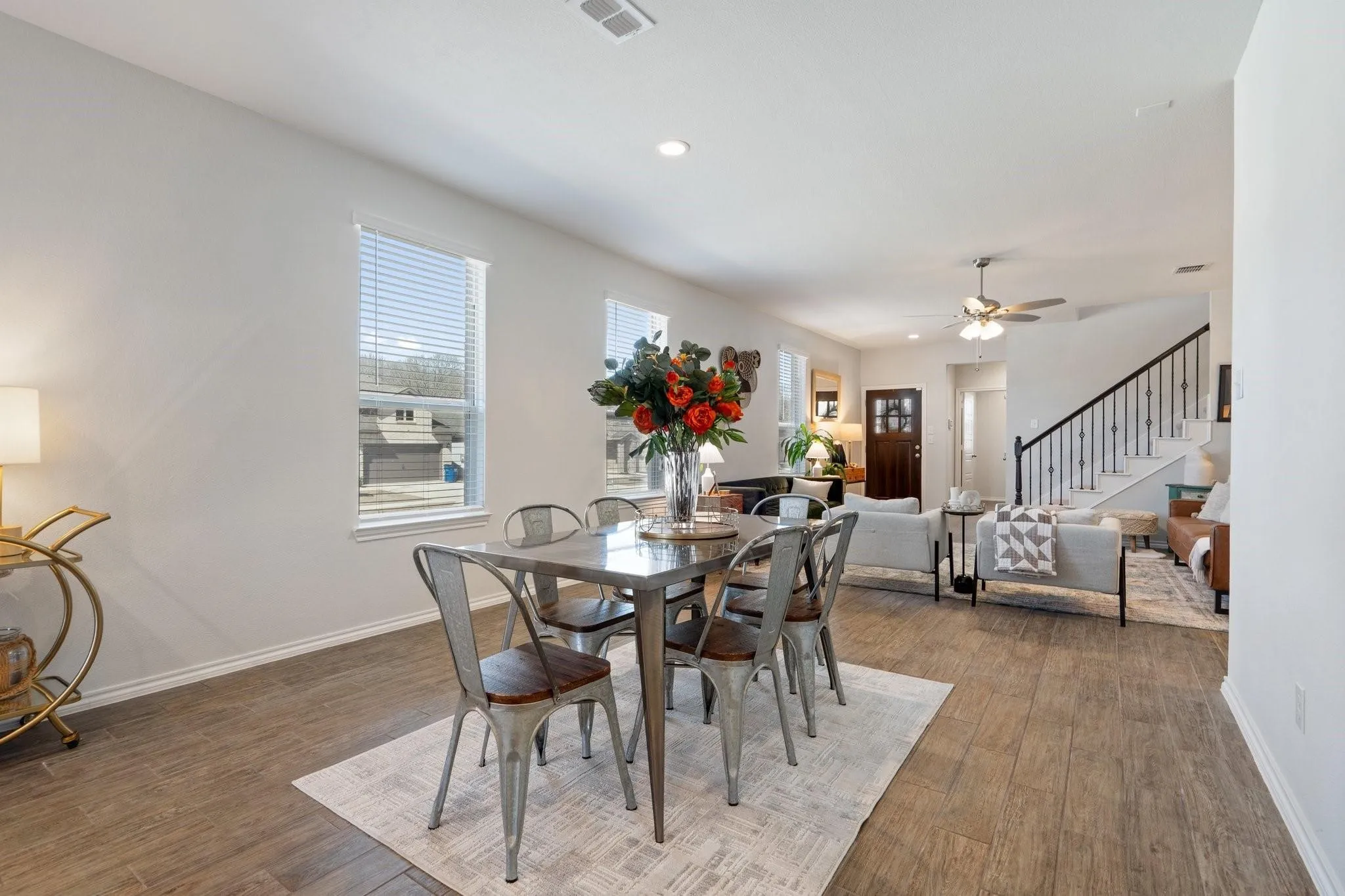 Dining space with baseboards, visible vents, a ceiling fan, wood finished floors, and stairway