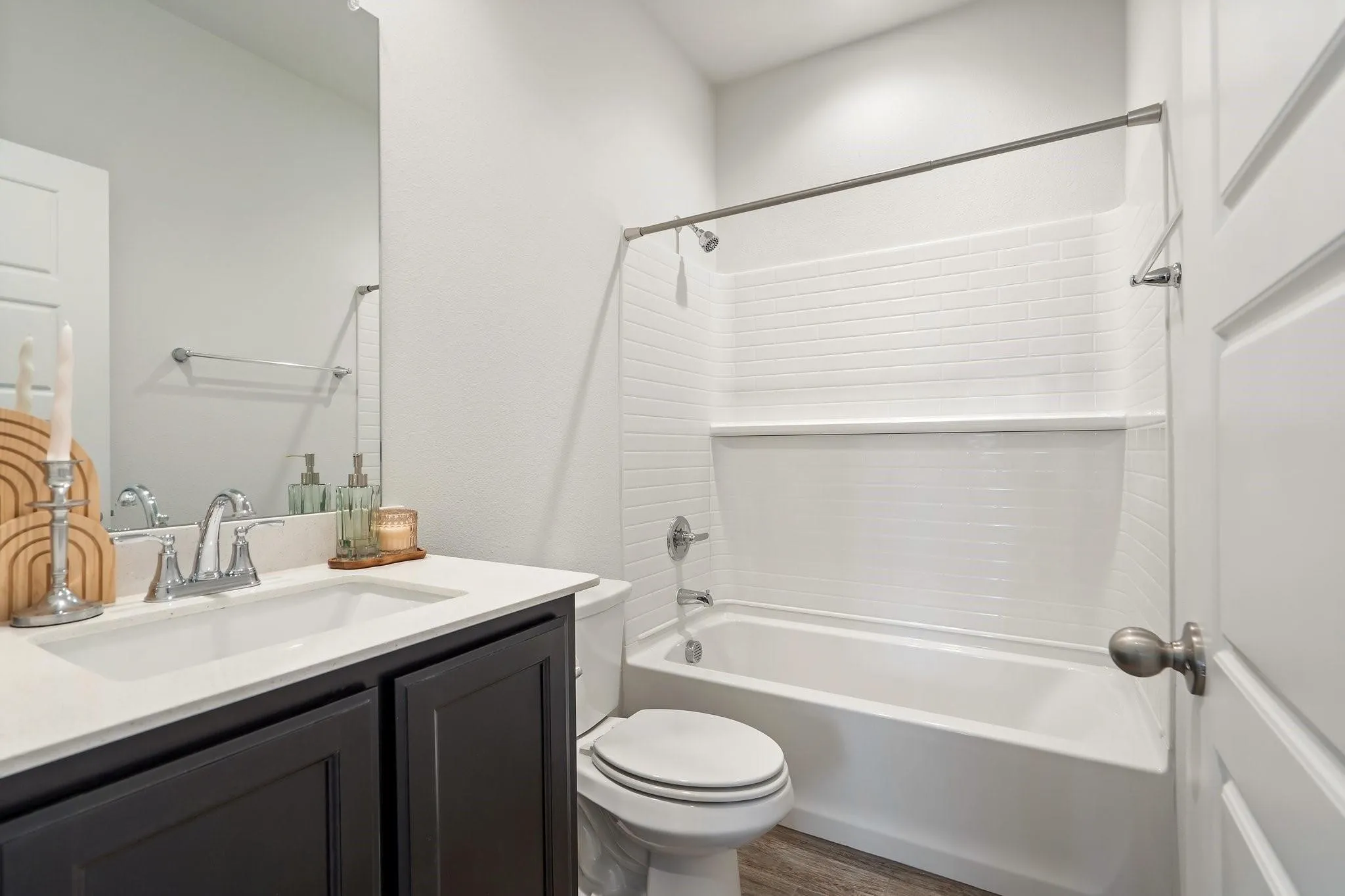 Bathroom with tub / shower combination, wood finished floors, toilet, and vanity