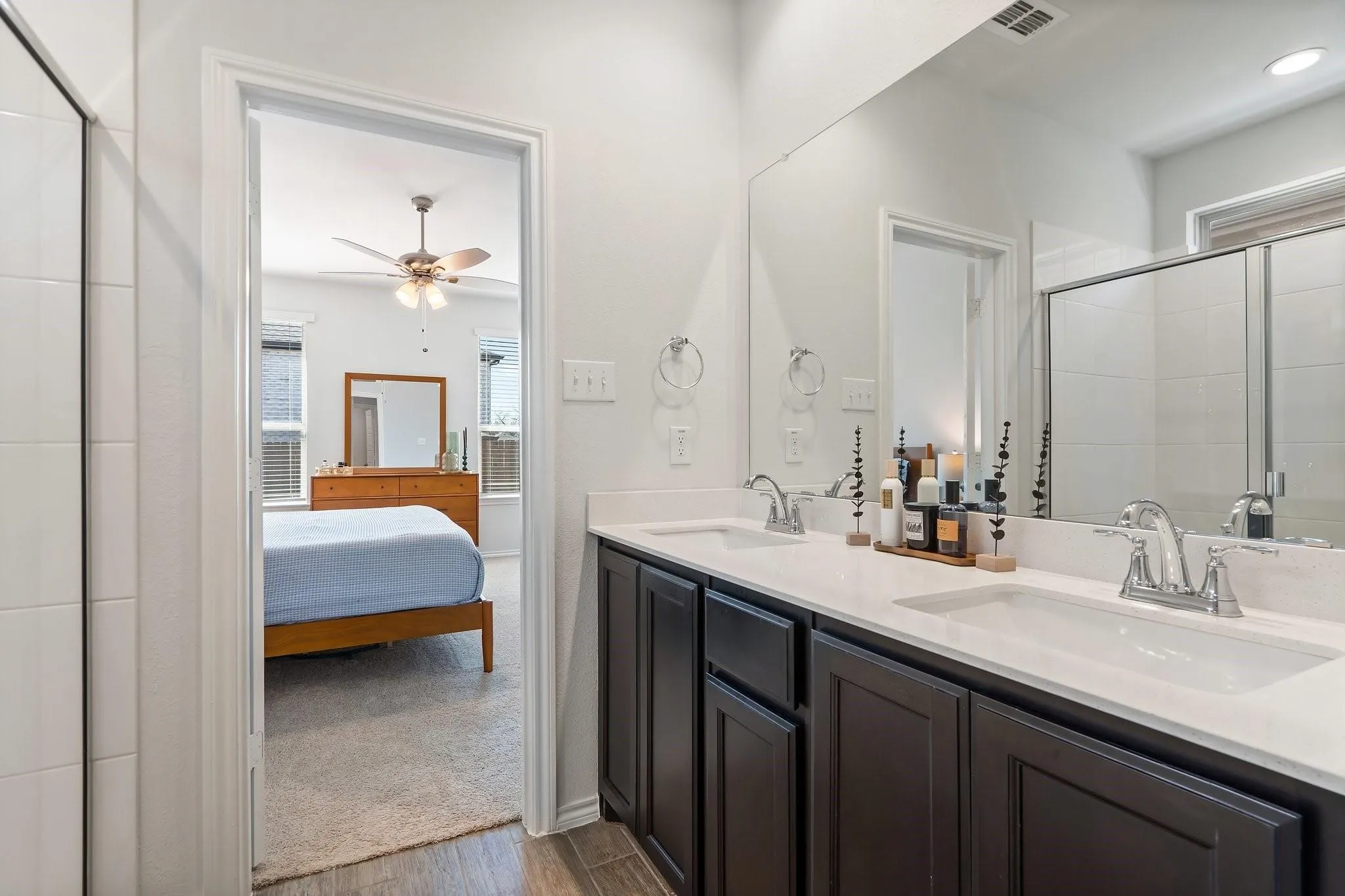 Ensuite bathroom featuring wood finished floors, ensuite bath, a ceiling fan, and a sink
