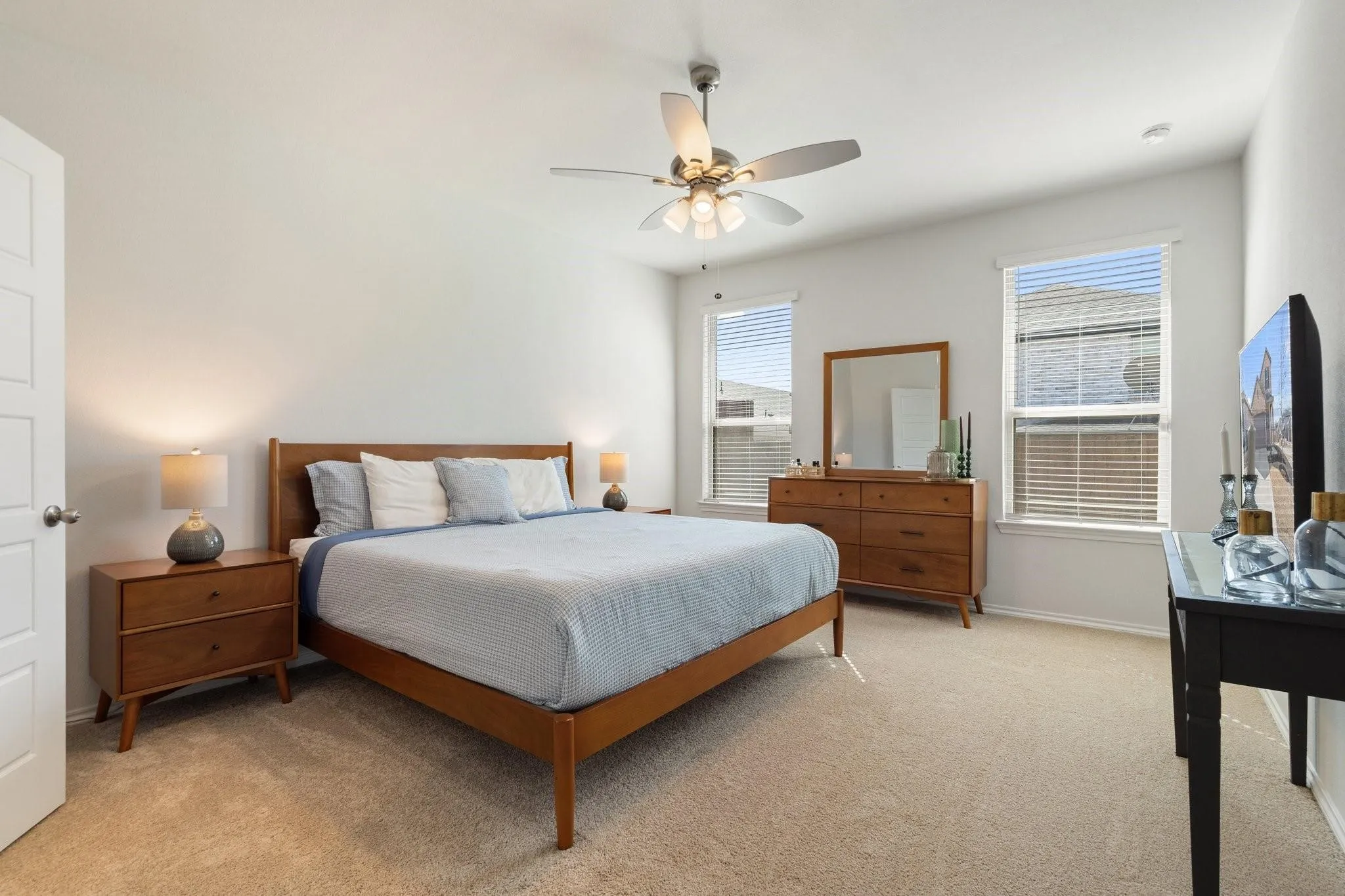 Bedroom featuring light carpet, a ceiling fan, and baseboards