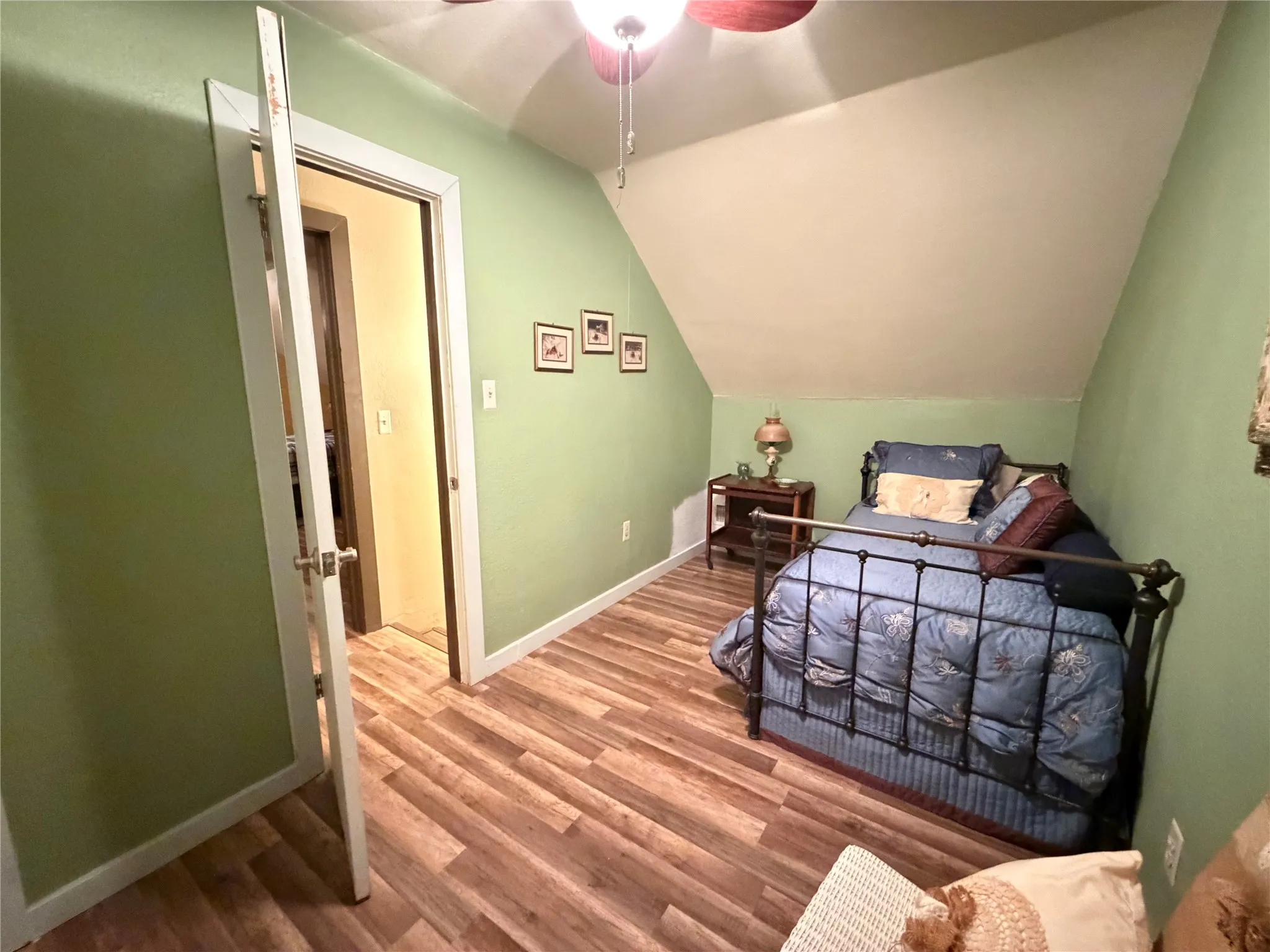 Wood-finish flooring with light green walls and a sloped ceiling