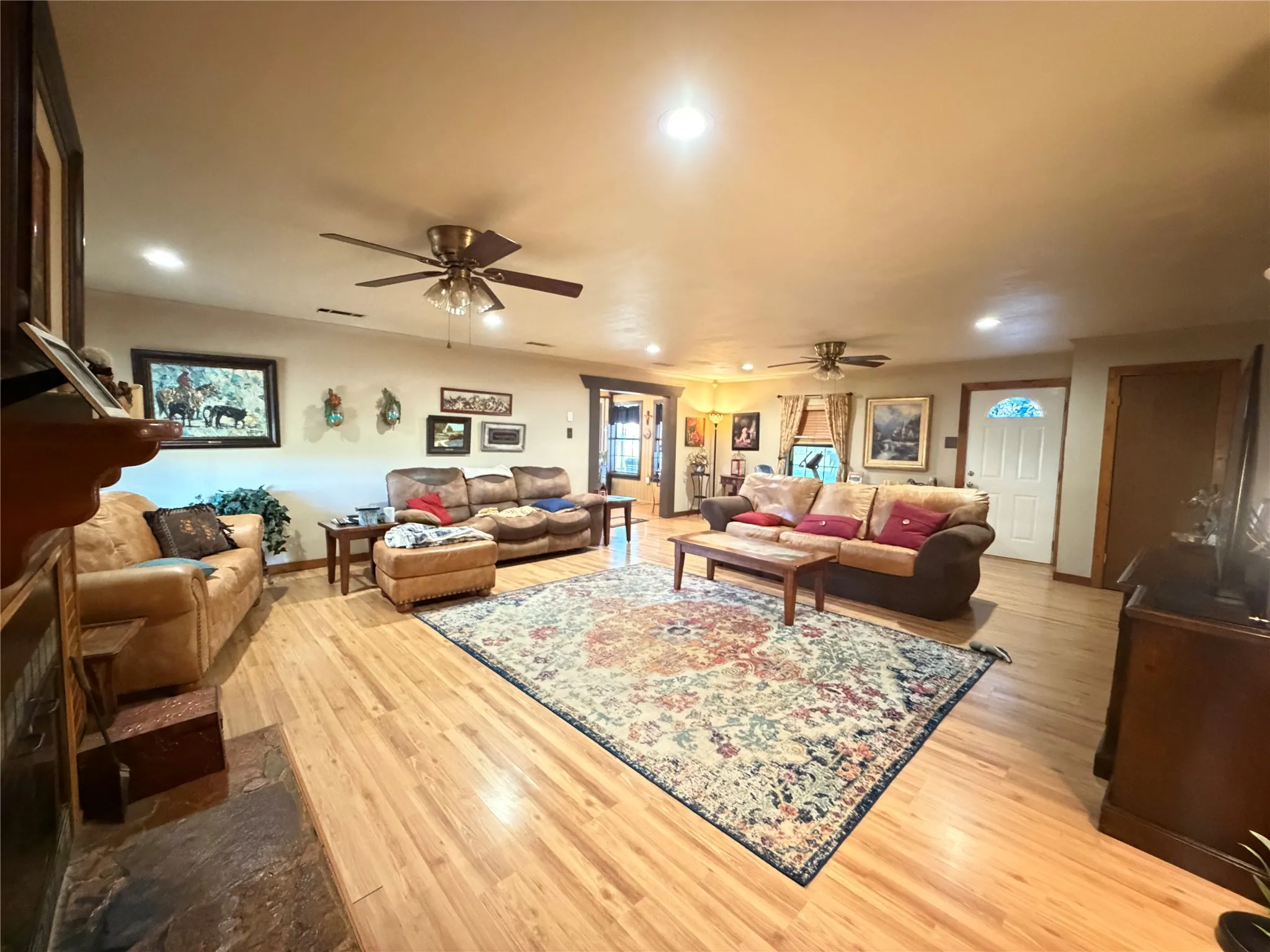 Spacious interior featuring wood-finish flooring, recessed lighting, and ceiling fans