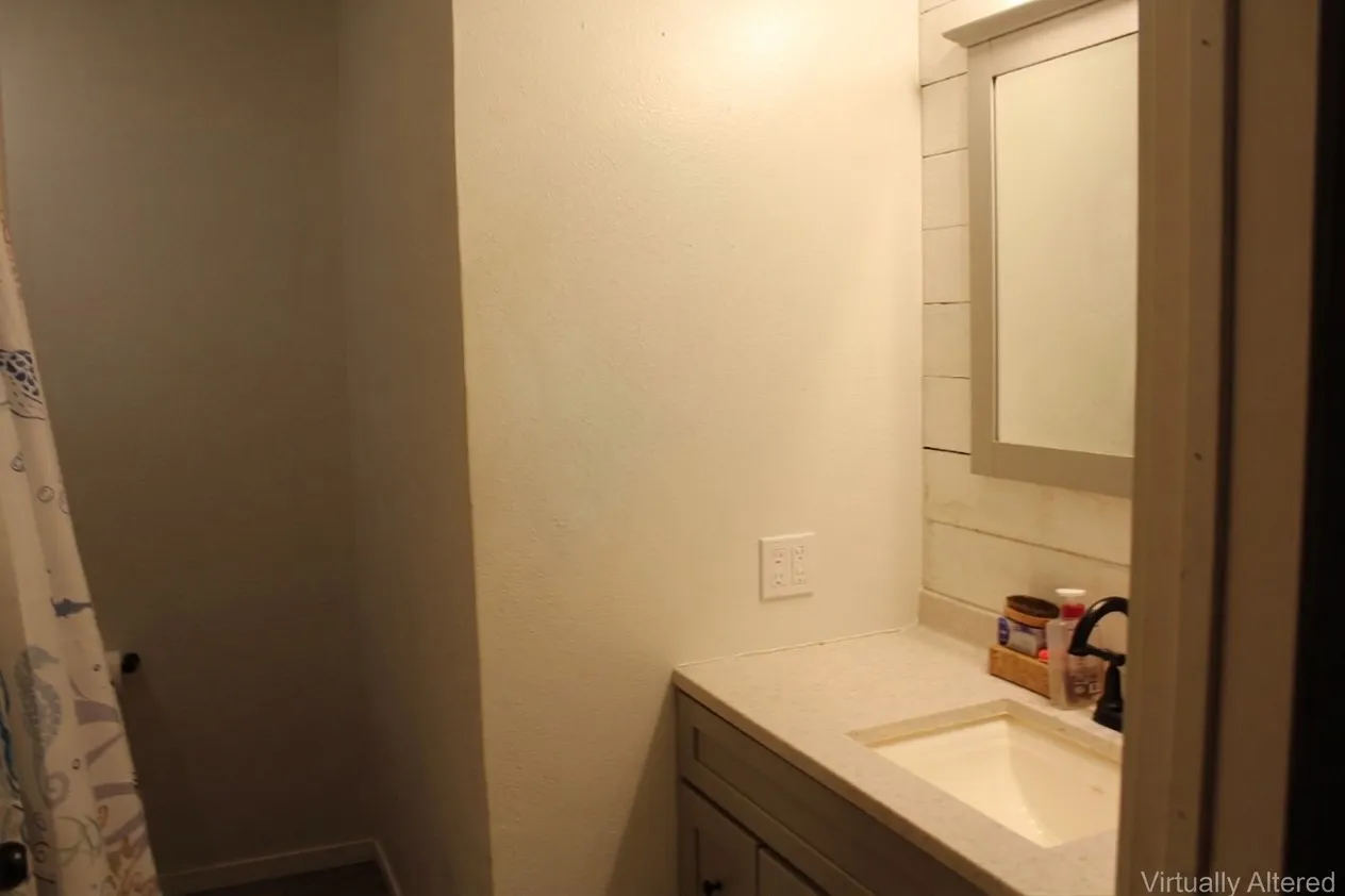 Vanity with an integrated sink, black faucet, and light-toned countertop