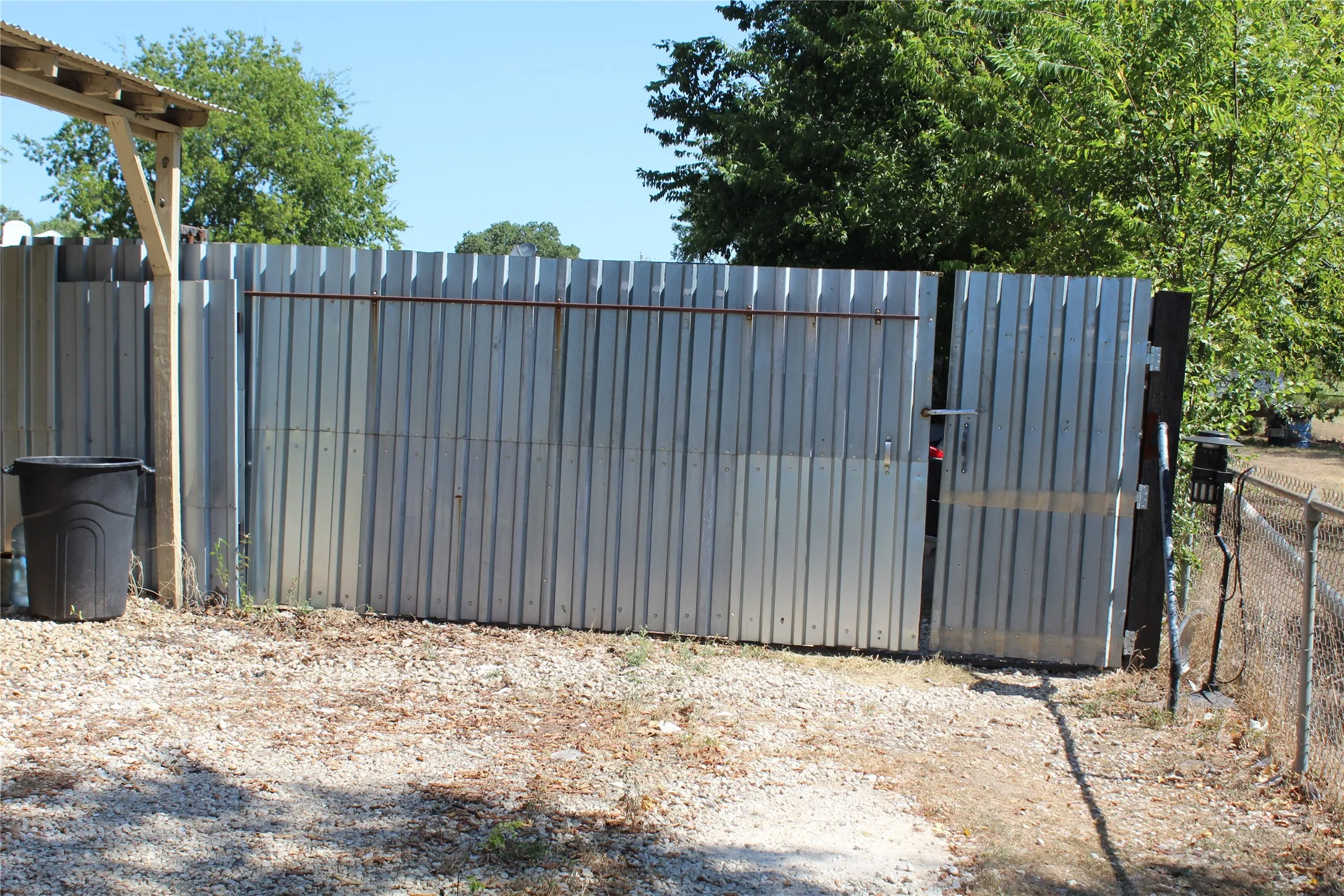 Corrugated metal fence with an access gate