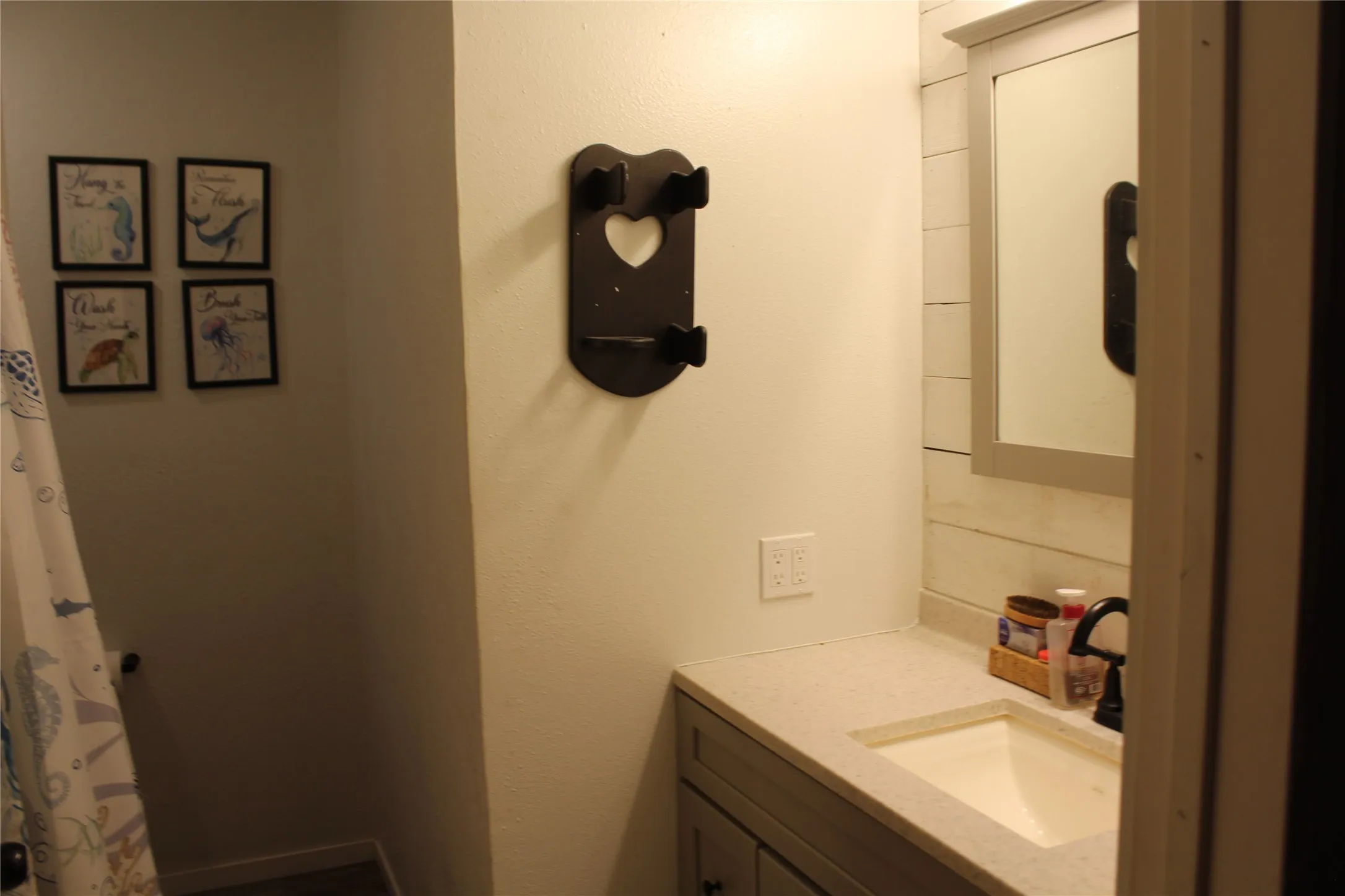 Vanity with integrated sink, light-toned countertop, and dark-finished faucet