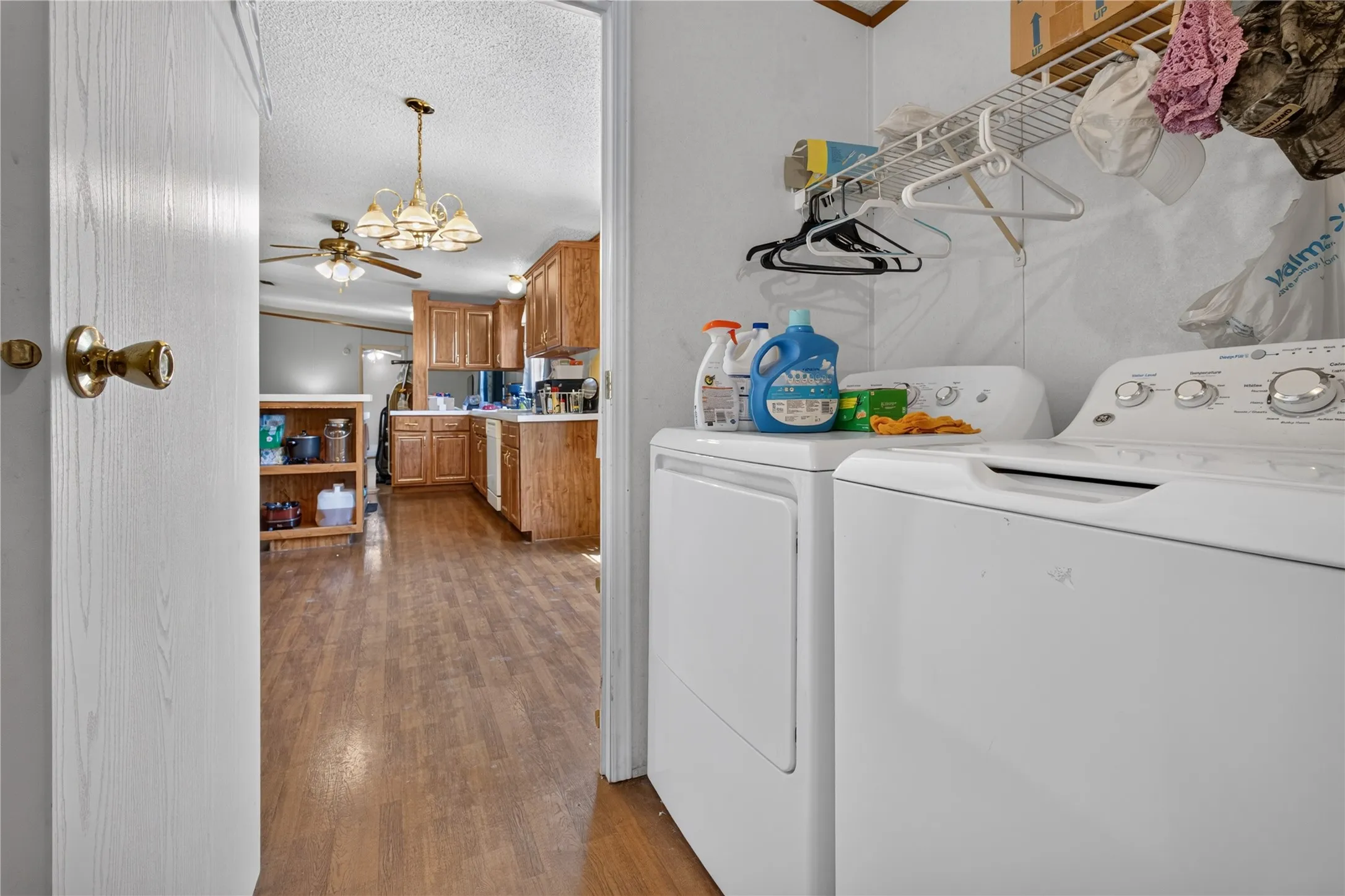 Dedicated laundry space featuring a white washer and dryer, complete with overhead wire shelving