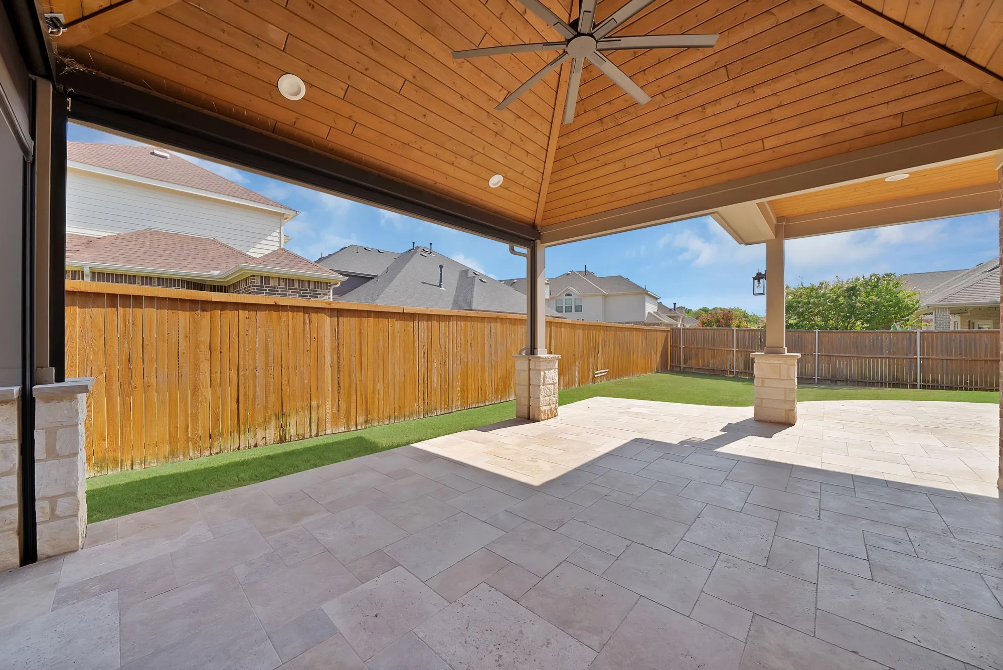 Expansive covered patio featuring a wood-panel ceiling, recessed lighting, and a ceiling fan
