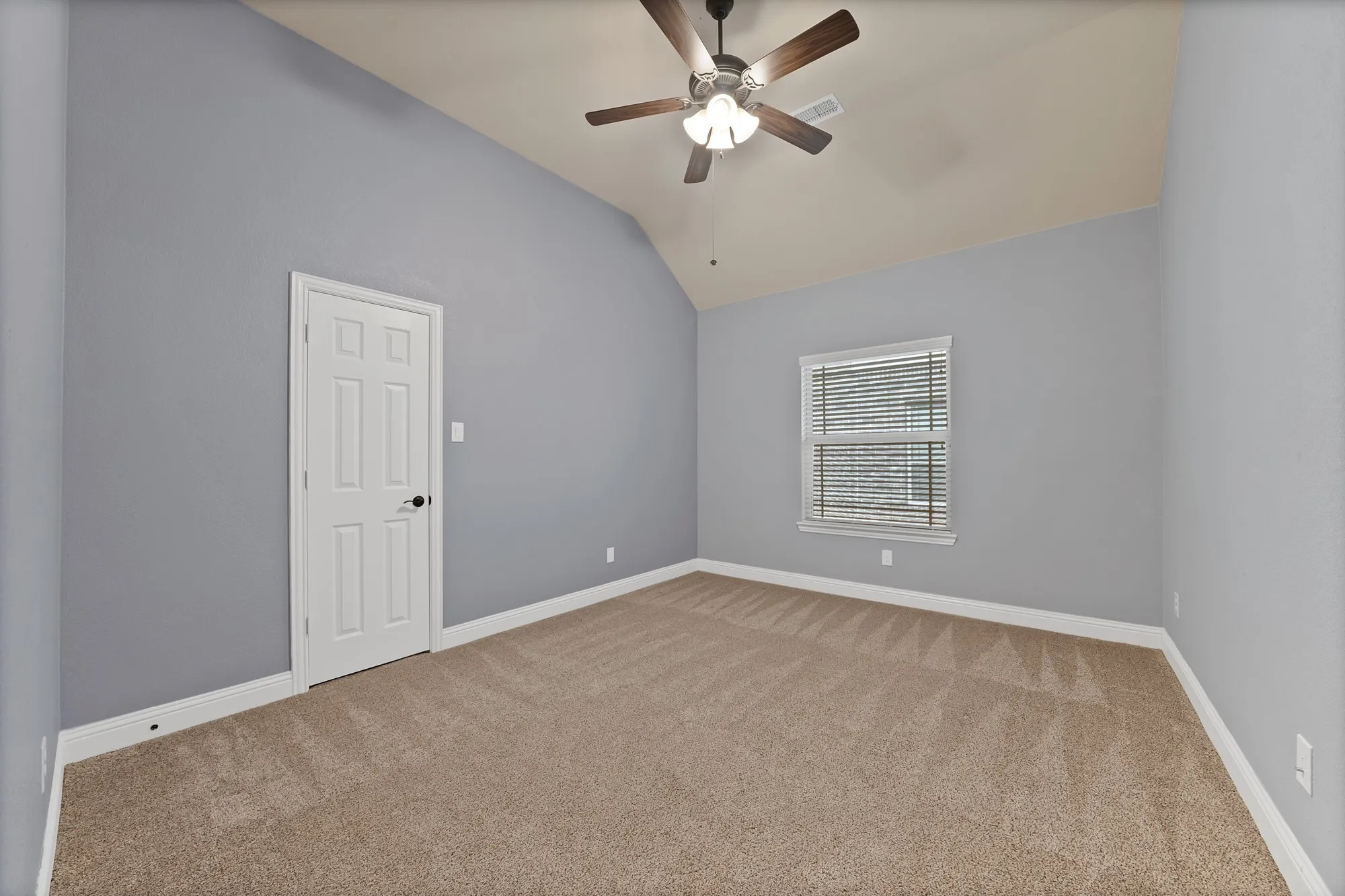 Vaulted ceiling with a ceiling fan, carpeted flooring, and a single window with blinds