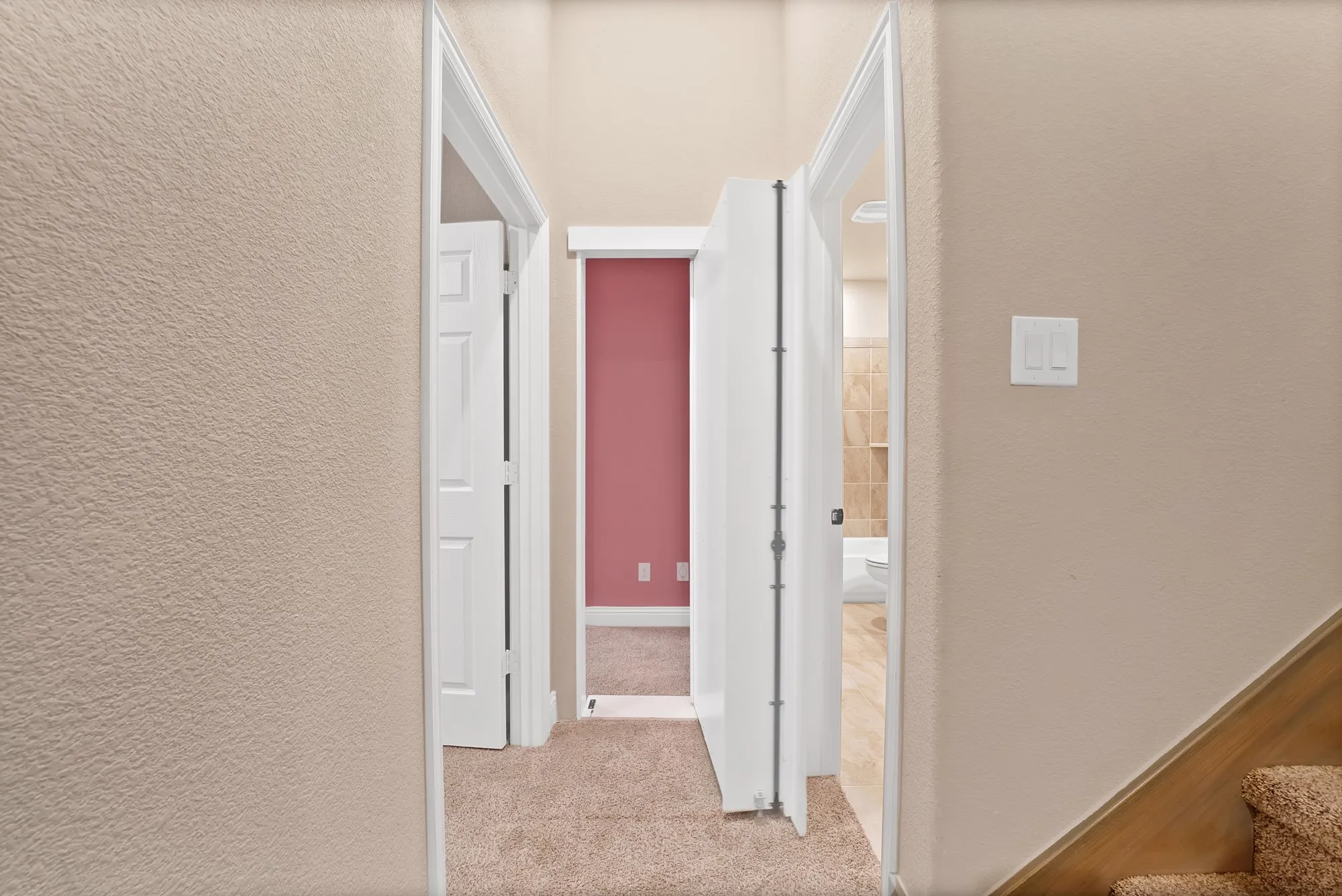 Textured walls with neutral paint, white trim, and a carpeted hallway