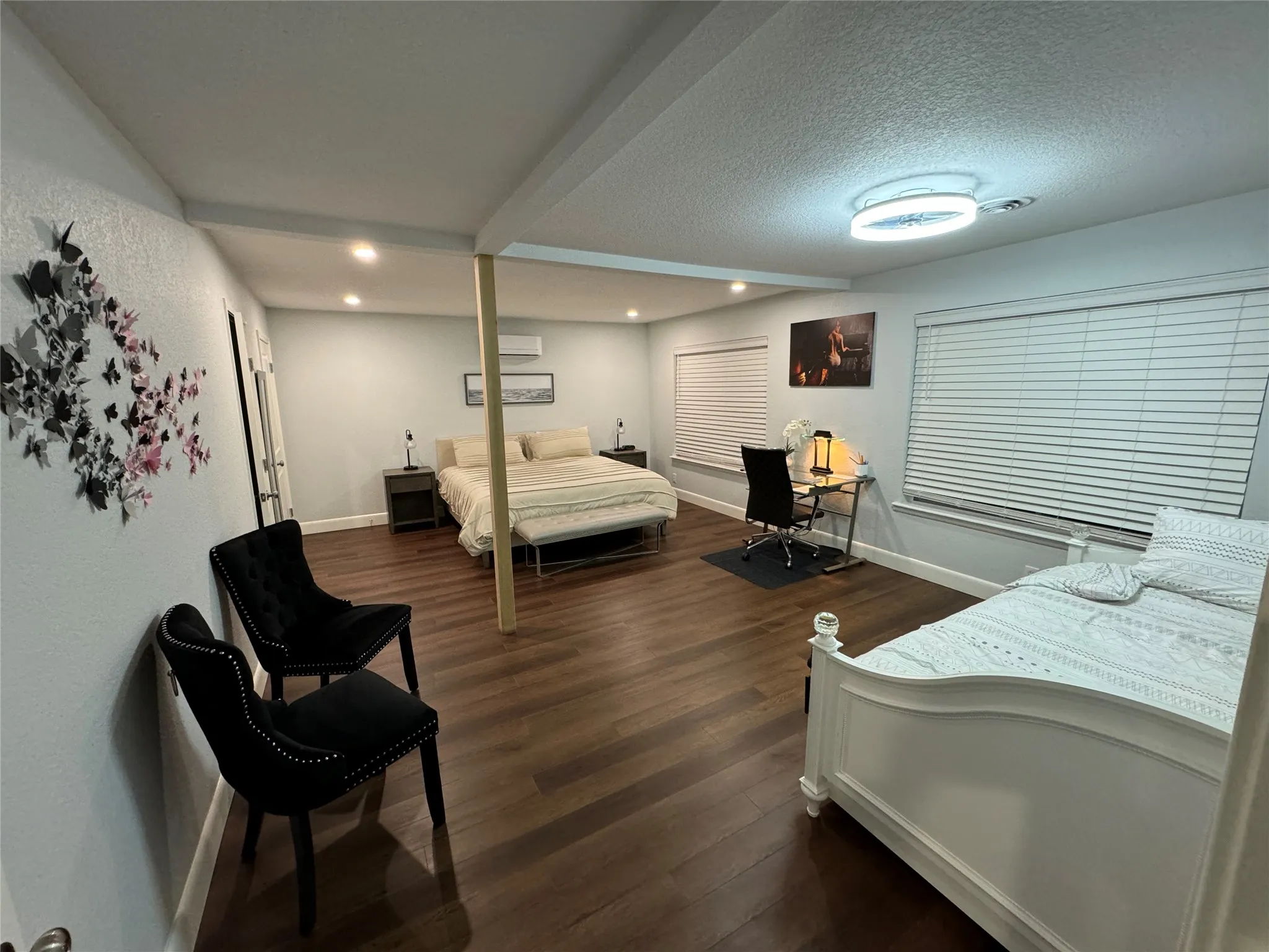 Wood-finish flooring, recessed lighting, white window blinds, and an exposed structural beam
