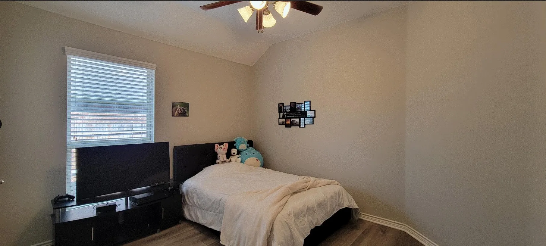 Vaulted ceiling with a ceiling fan, wood-finish flooring, and window with blinds