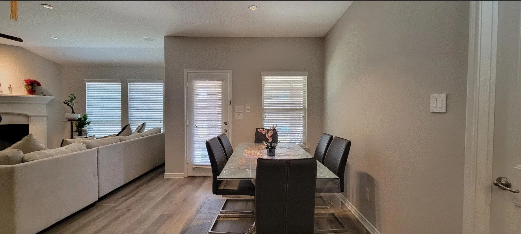 Wood-finish flooring throughout, recessed lighting, and a rear exterior door with integrated blinds