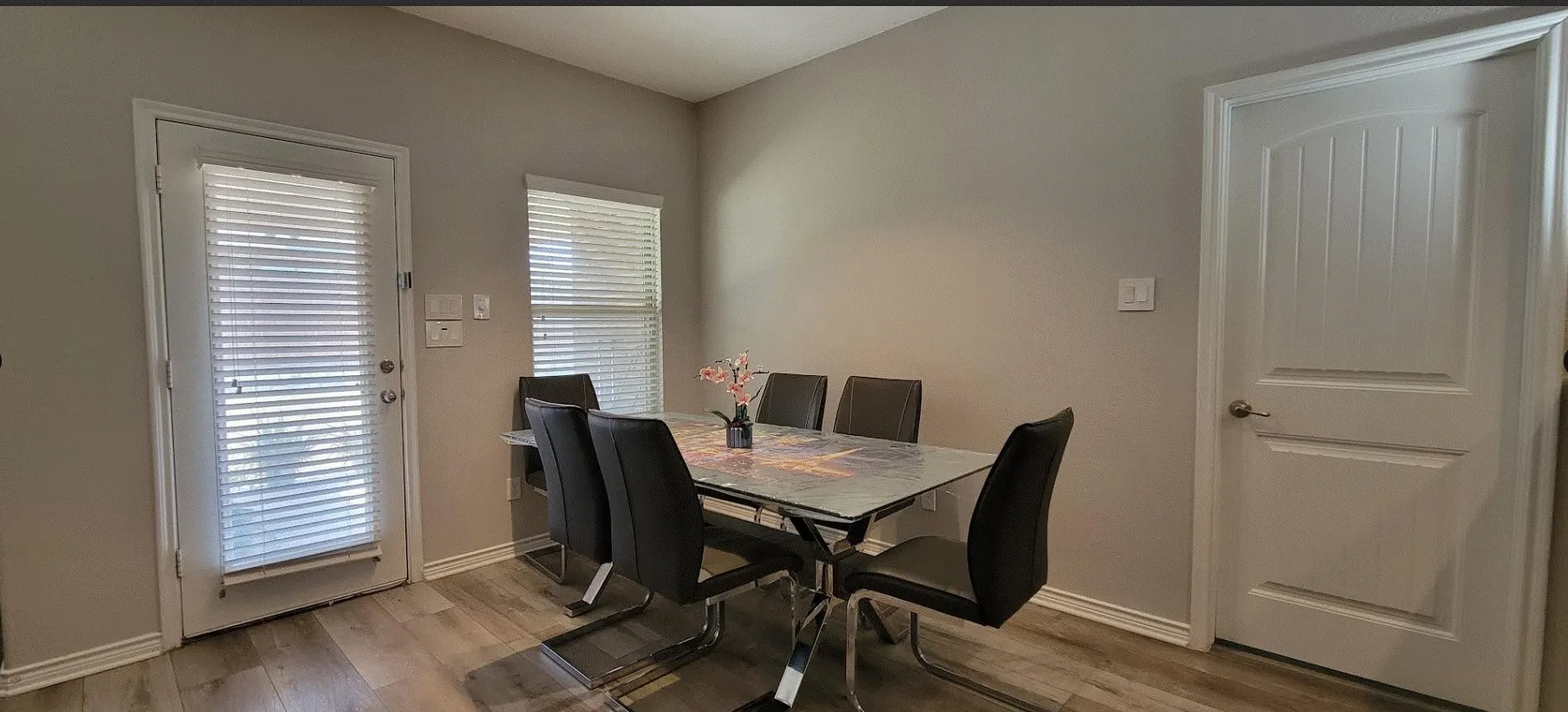 Wood-finish flooring throughout, multiple windows with blinds, and white interior doors