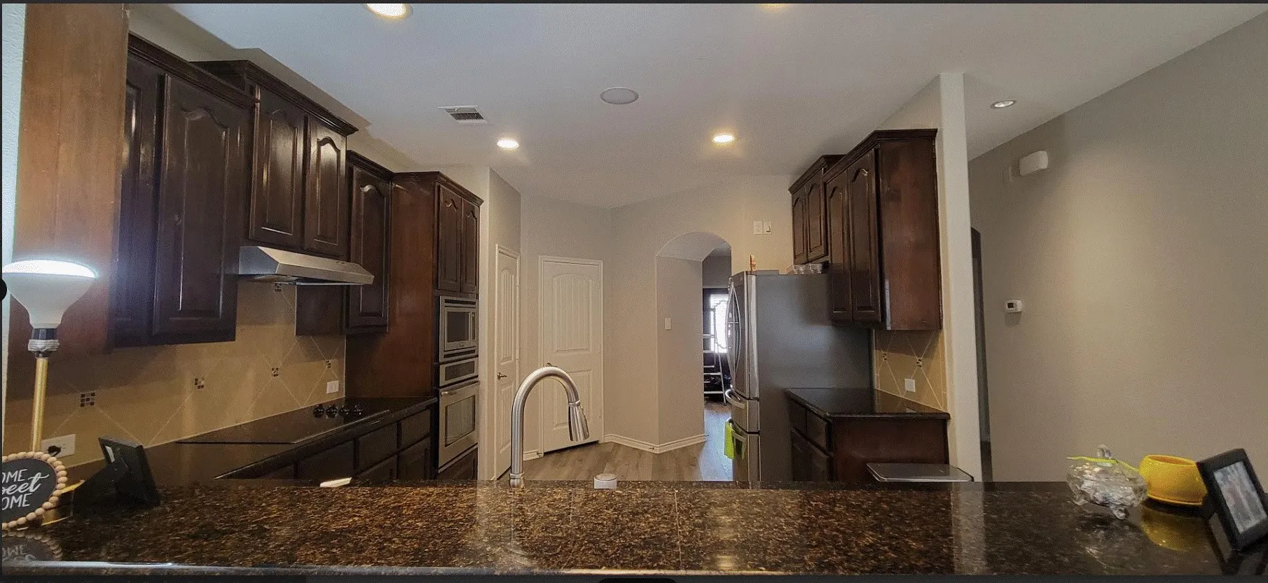 Chef's kitchen featuring rich wood cabinetry, granite countertops, stainless steel appliances, and a professional-style faucet with pull-down spray