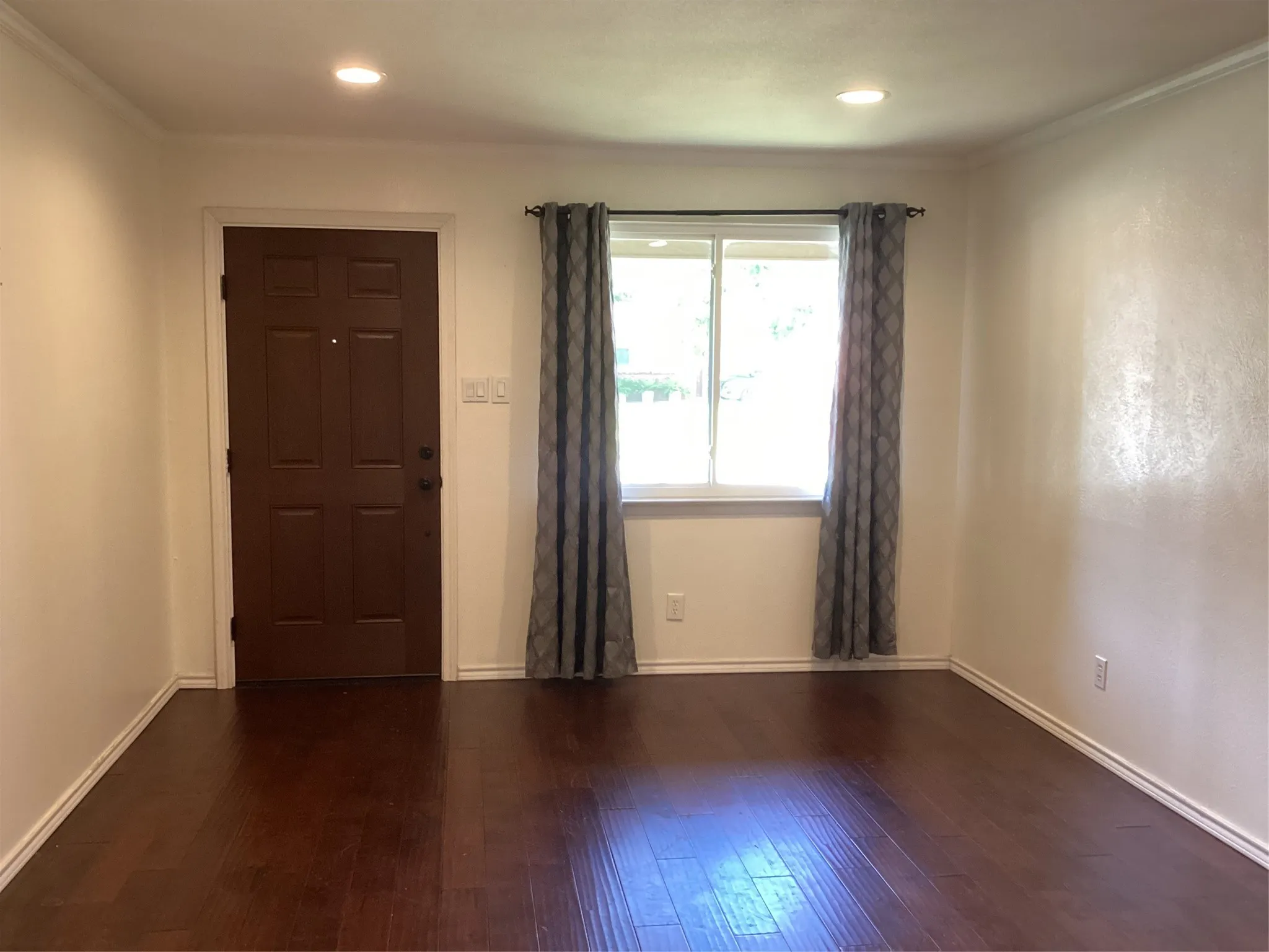 Recessed lighting illuminates wood-finish flooring