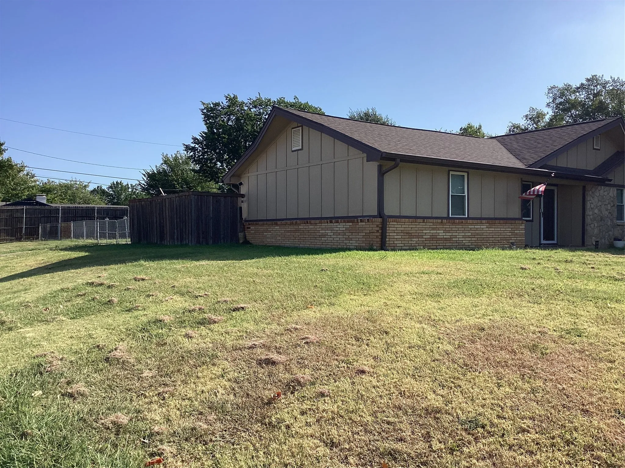 Expansive yard featuring a wooden privacy fence and a chain link fence