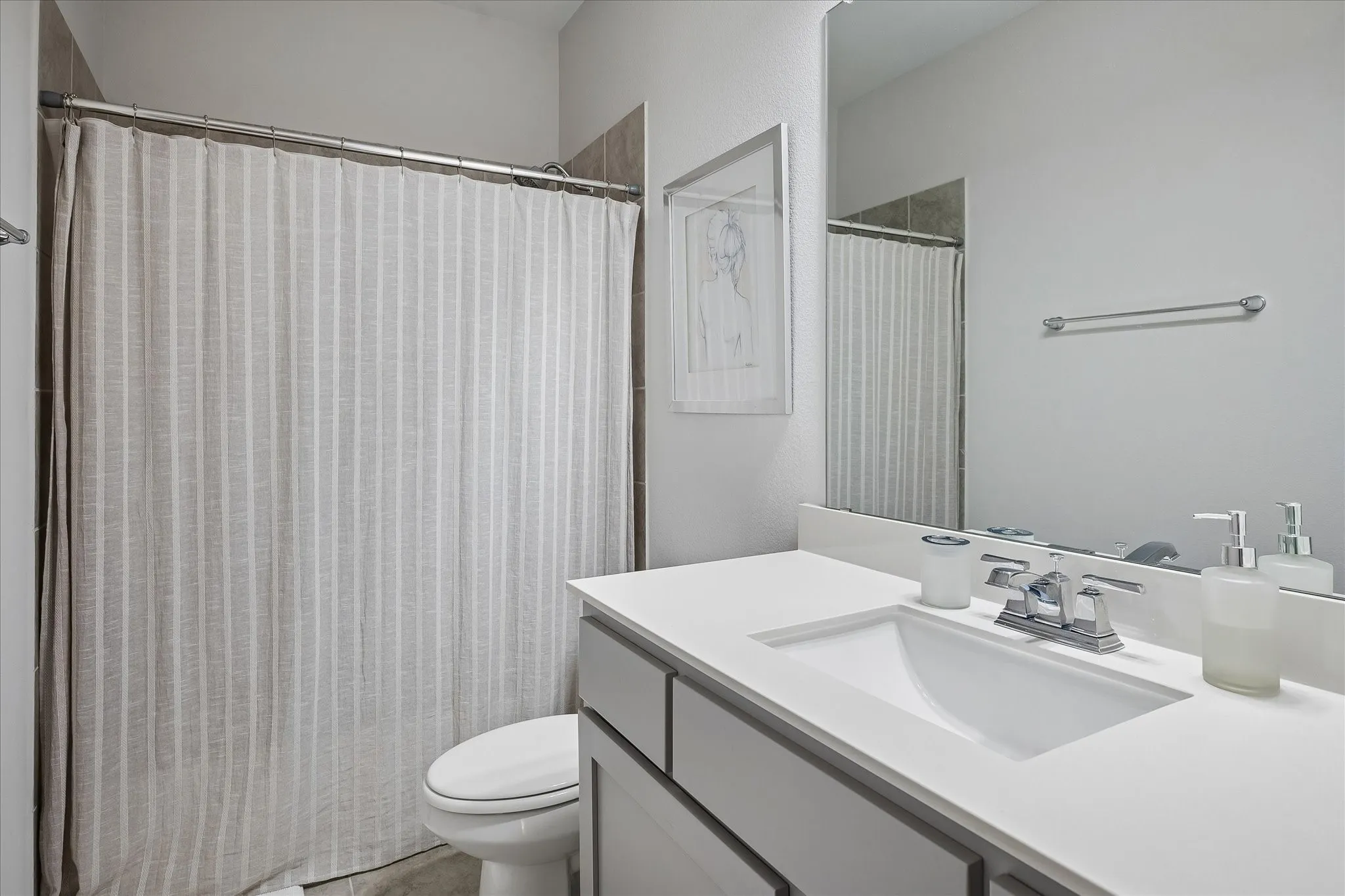 Upstairs Full Bathroom featuring a vanity with a white countertop and integrated sink, chrome faucet, wall-mounted mirror, and a tiled shower.